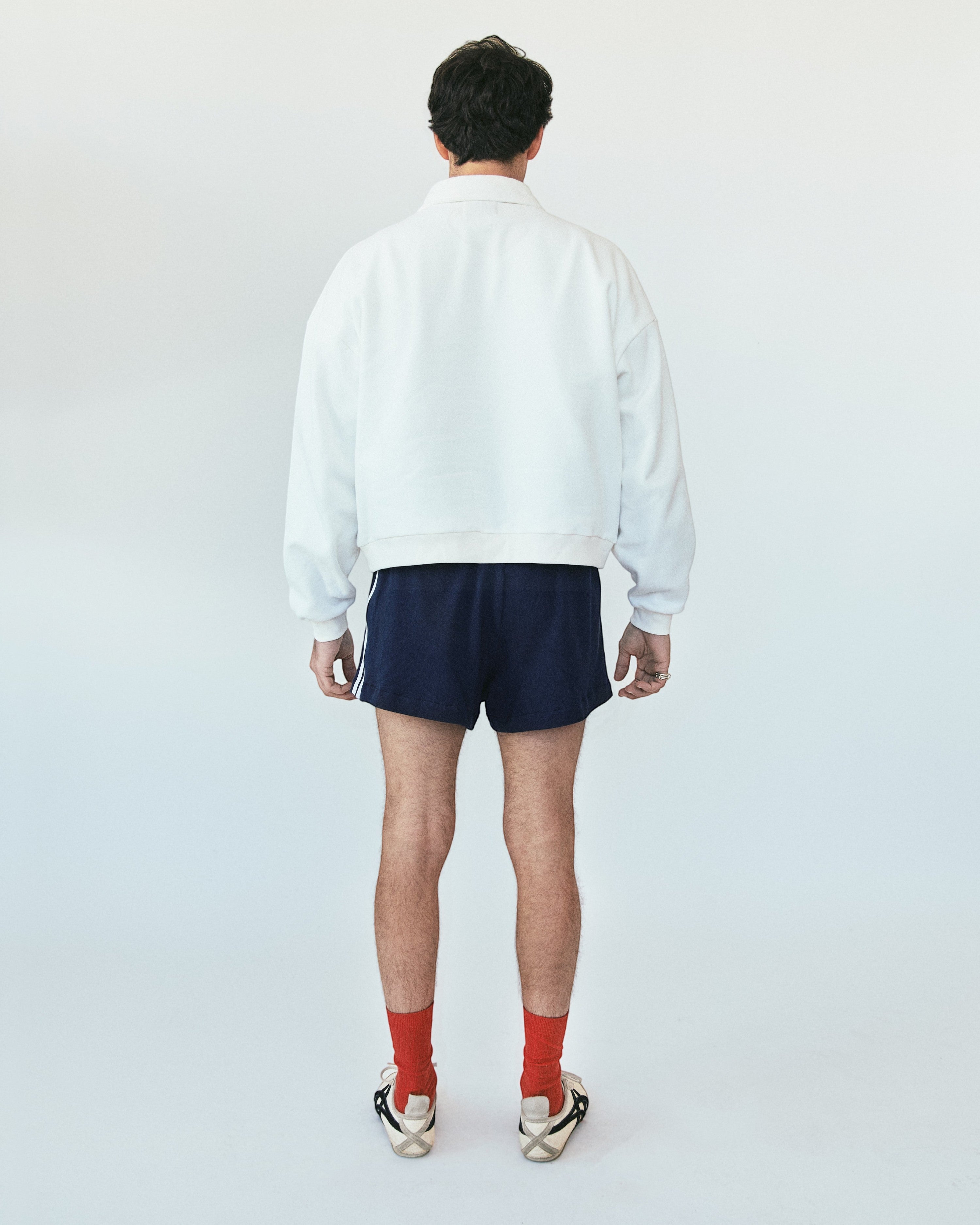 Weldun white oversized cotton polo sweatshirt with ribbed collar and cuffs worn by a man from the back view