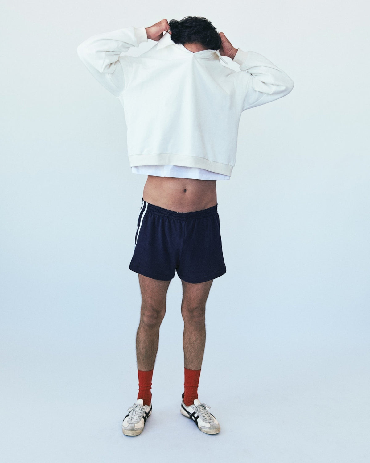 Weldun H-O-R-S-E navy cotton terry basketball shorts with white side stripes worn by a model in a studio setting