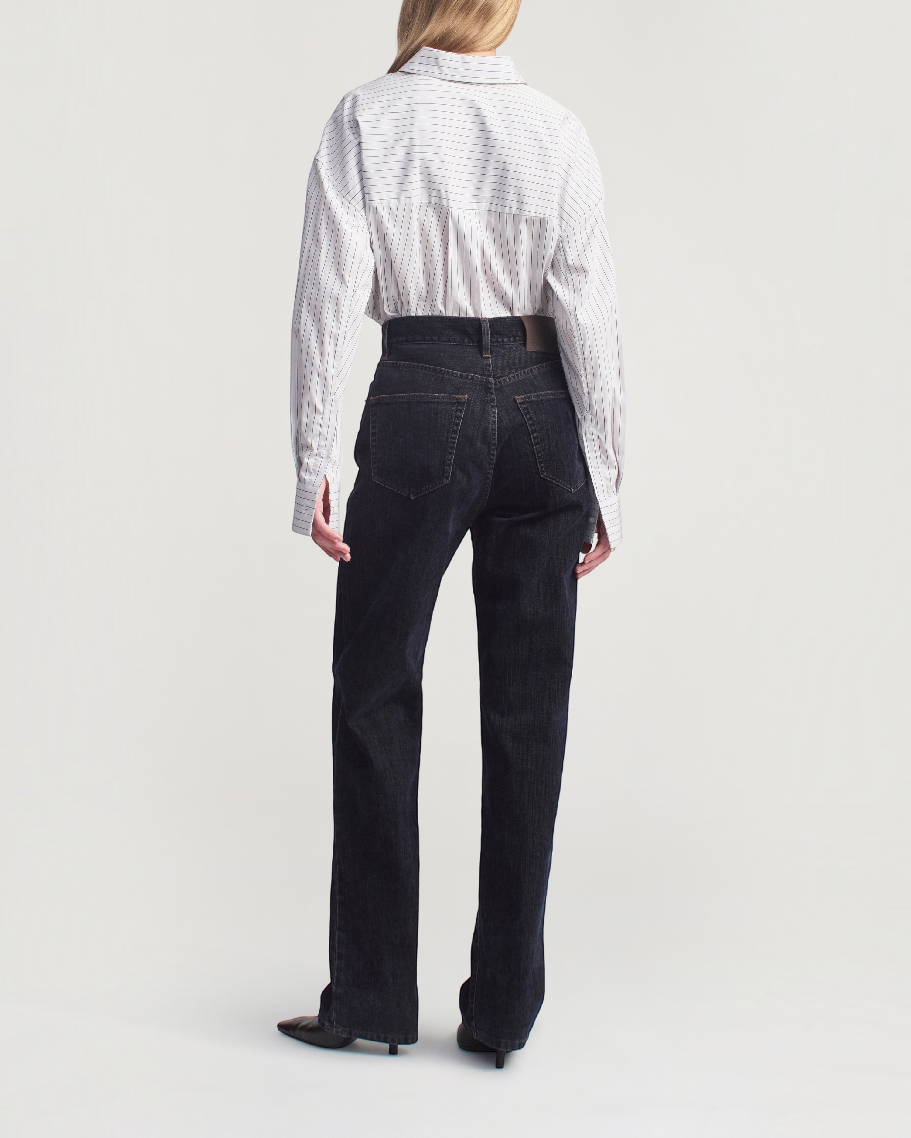 Weldun Dani button down shirt in navy stripe cotton poplin worn with dark denim jeans, back view