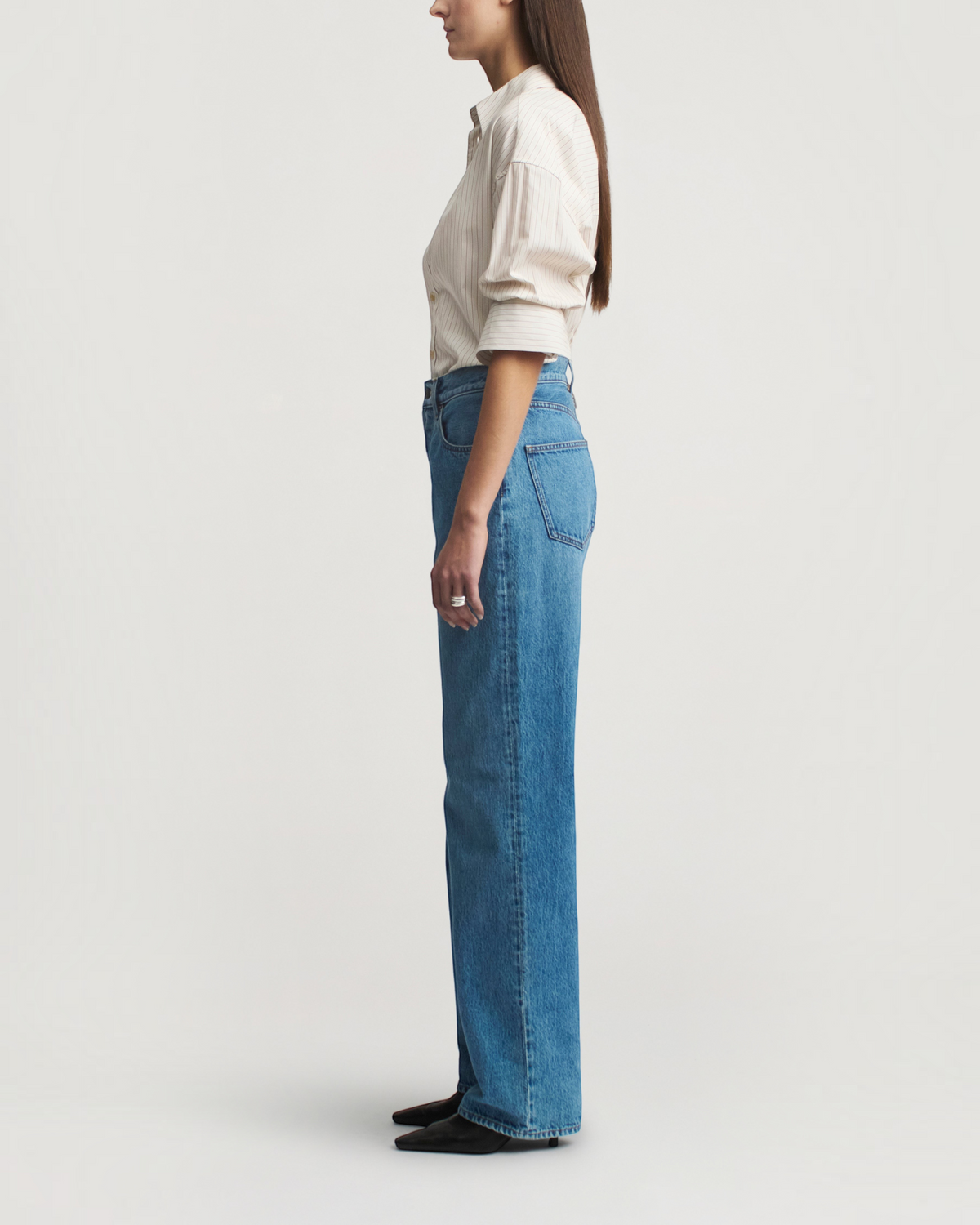 Weldun Dani button down shirt in sepia stripe cotton poplin worn by a model with blue jeans, side profile view