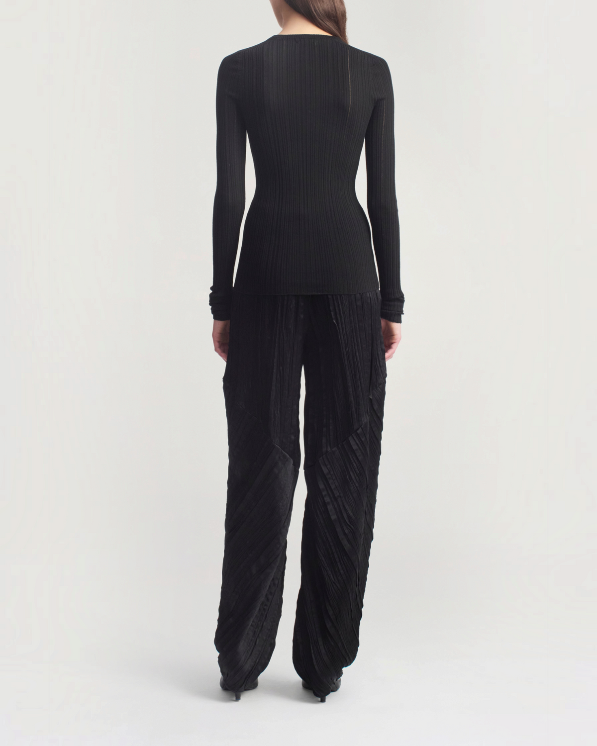 Weldun KALLMEYER black superfine pointelle long sleeve top with a fitted silhouette and ribbed texture, back view.