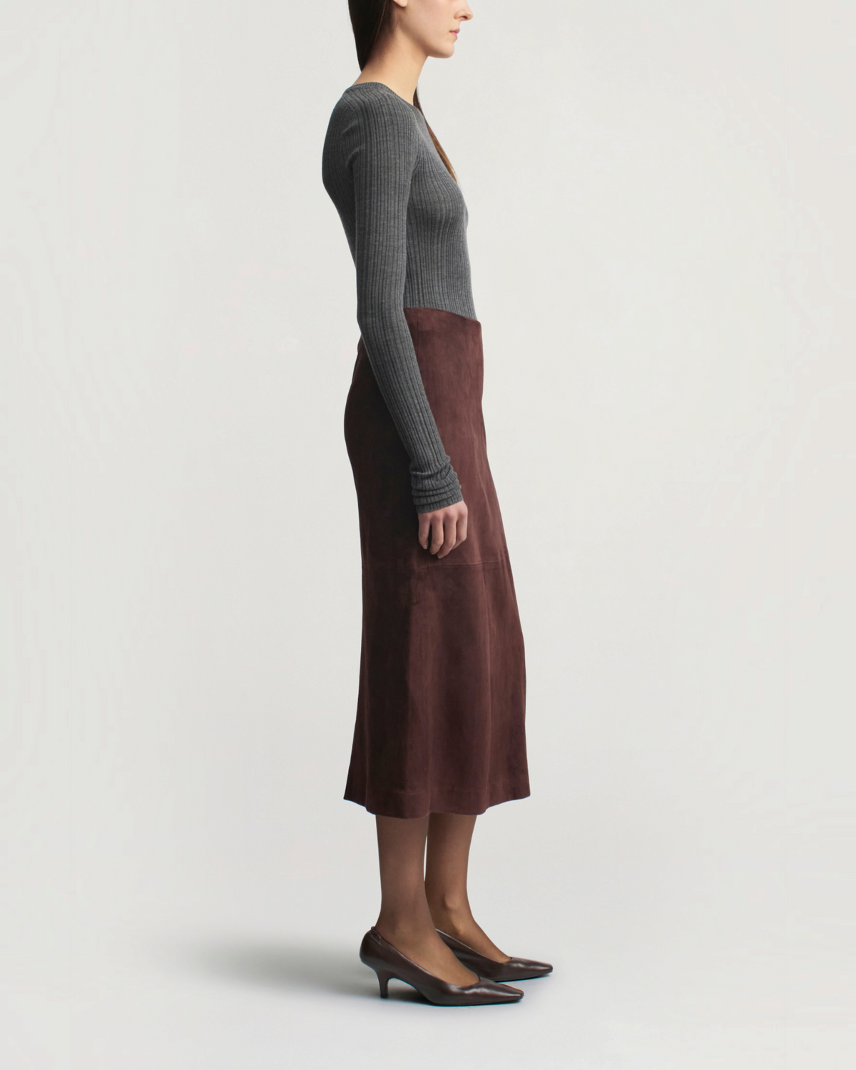 Weldun model wearing a charcoal grey ribbed pointelle long sleeve top and a brown suede midi skirt with heels.