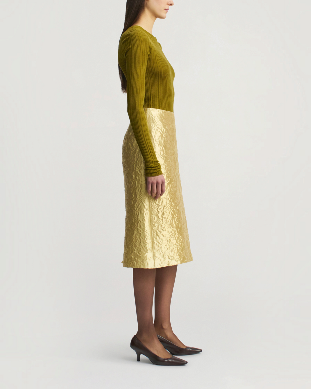 Weldun KALLMEYER olive green superfine pointelle long sleeve top worn with a gold textured midi skirt and heels.