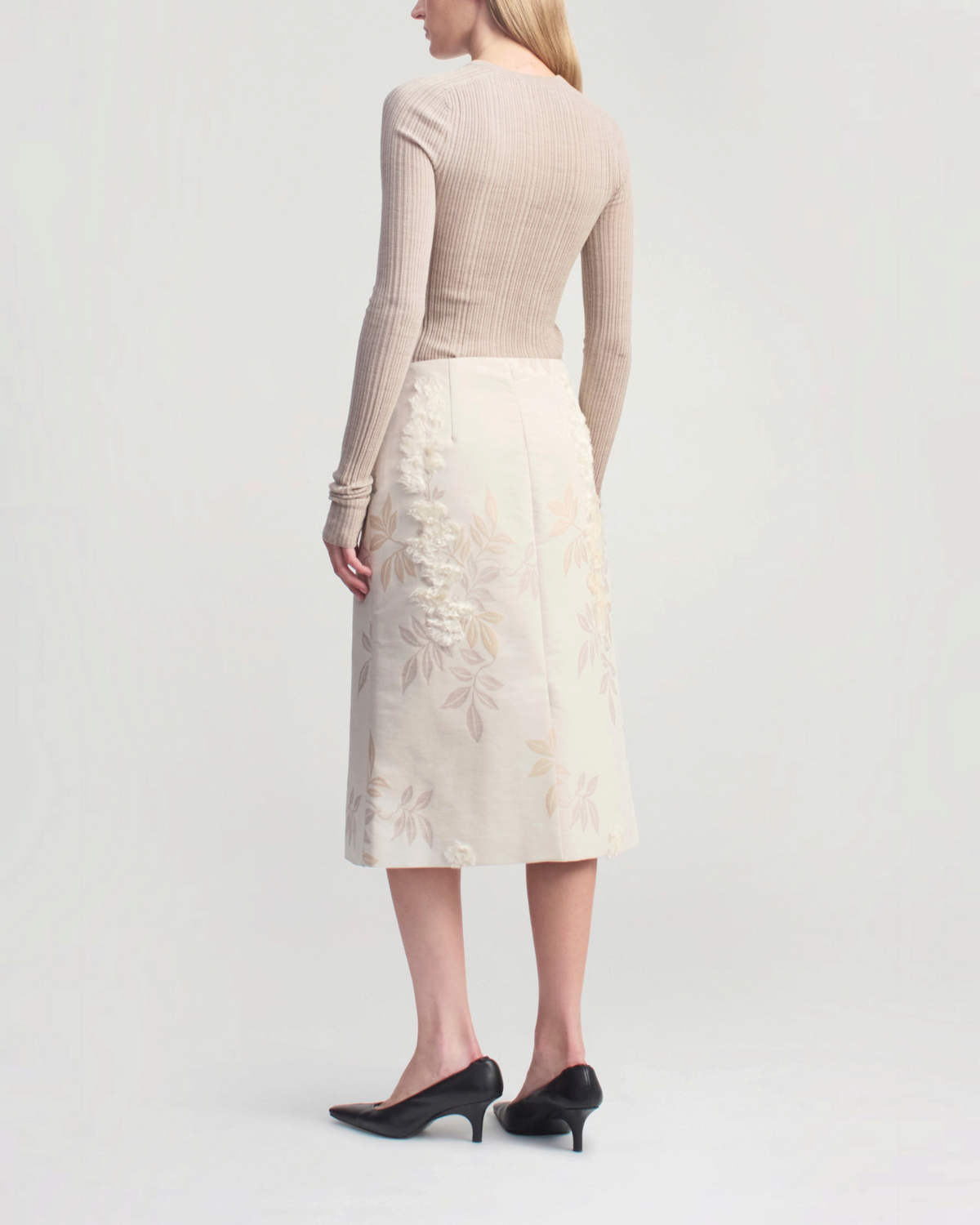 Weldun model wearing a beige ribbed pointelle long sleeve top and a floral midi skirt with black kitten heels