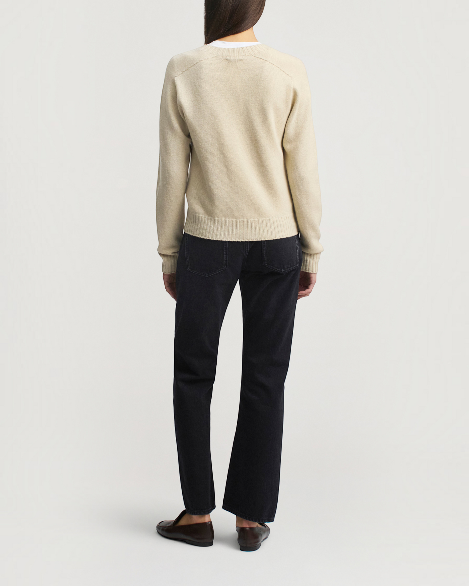 Weldun Nina seamless crewneck in birch cashmere wool with ribbed trim, worn with dark jeans and loafers, back view.