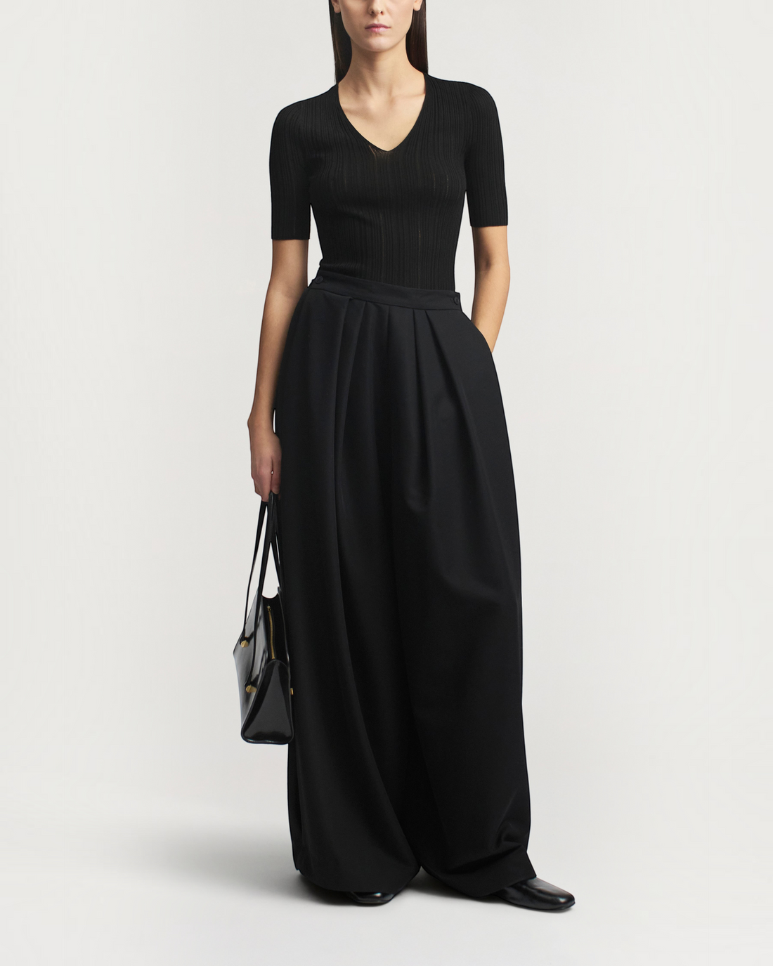 Weldun KALLMEYER Pika black superfine pointelle V-neck knit top with elbow-length sleeves worn with wide-leg trousers.