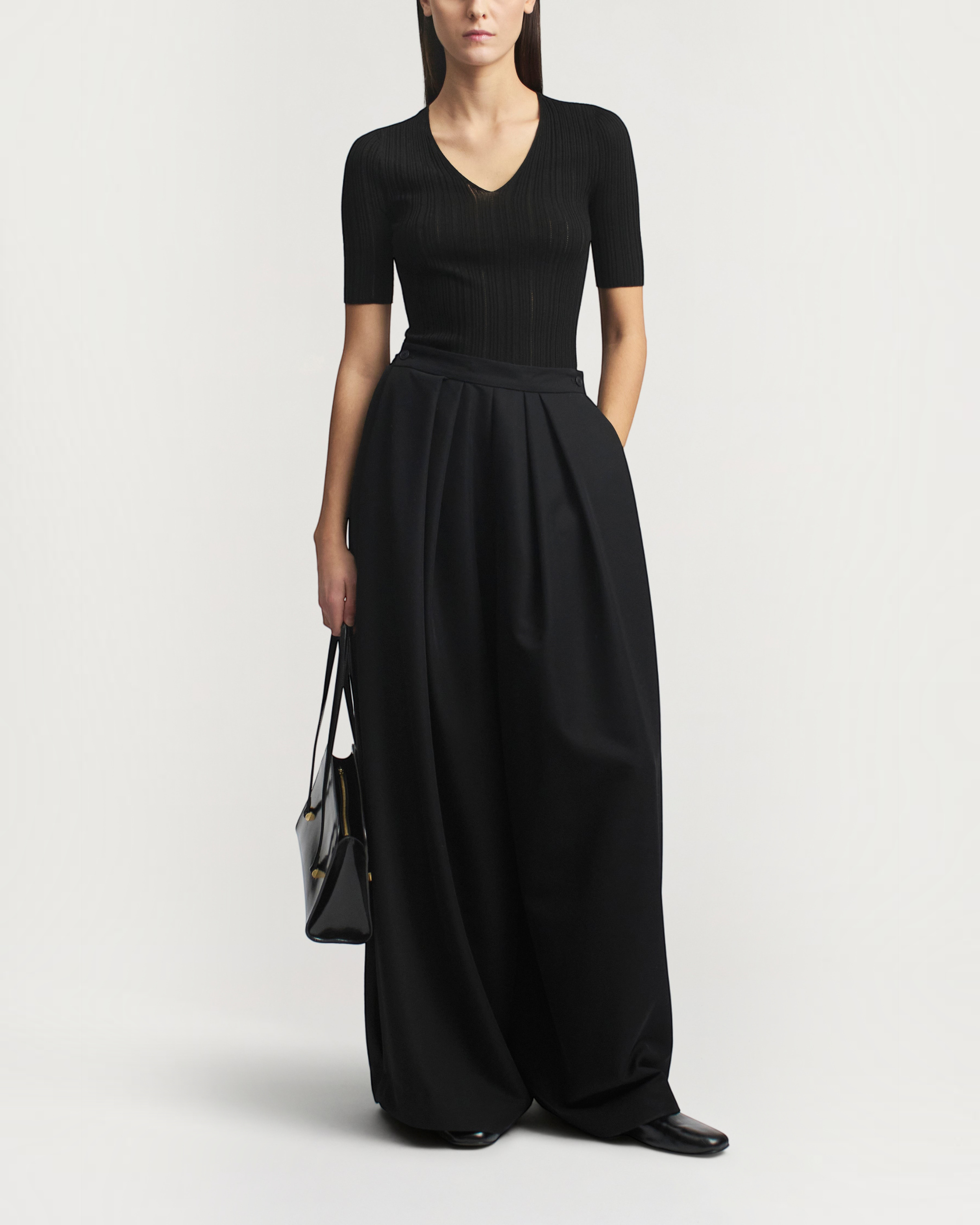 Weldun KALLMEYER Pika black superfine pointelle V-neck knit top with elbow-length sleeves worn with wide-leg trousers.