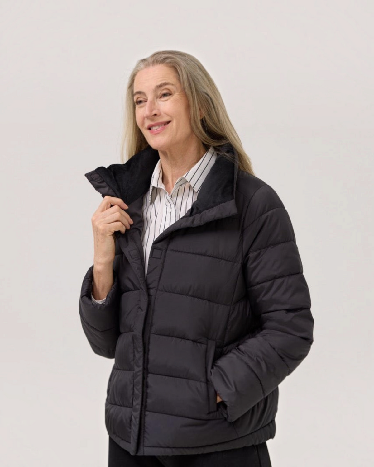 Weldun model wearing a black Weatherproof x MagnaReady magnetic front puffer jacket with a soft velboa-lined collar.