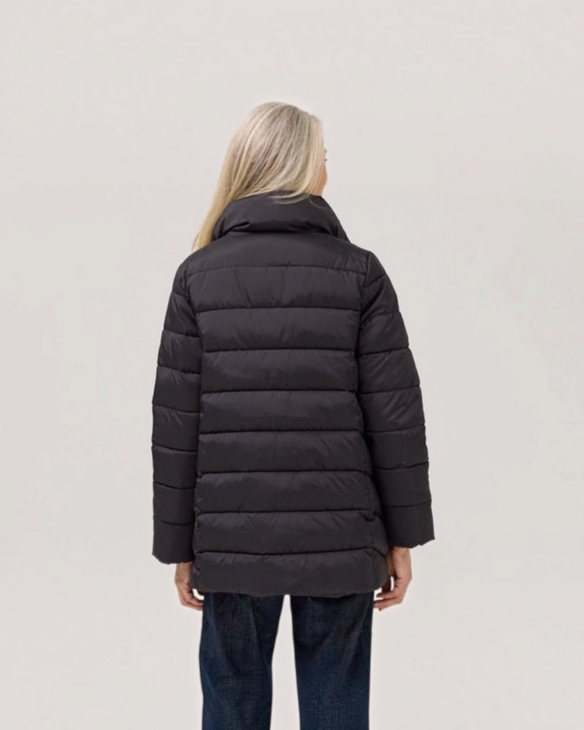 Back view of a Weldun Weatherproof x MagnaReady black mid-length puffer jacket with a high collar on a model.
