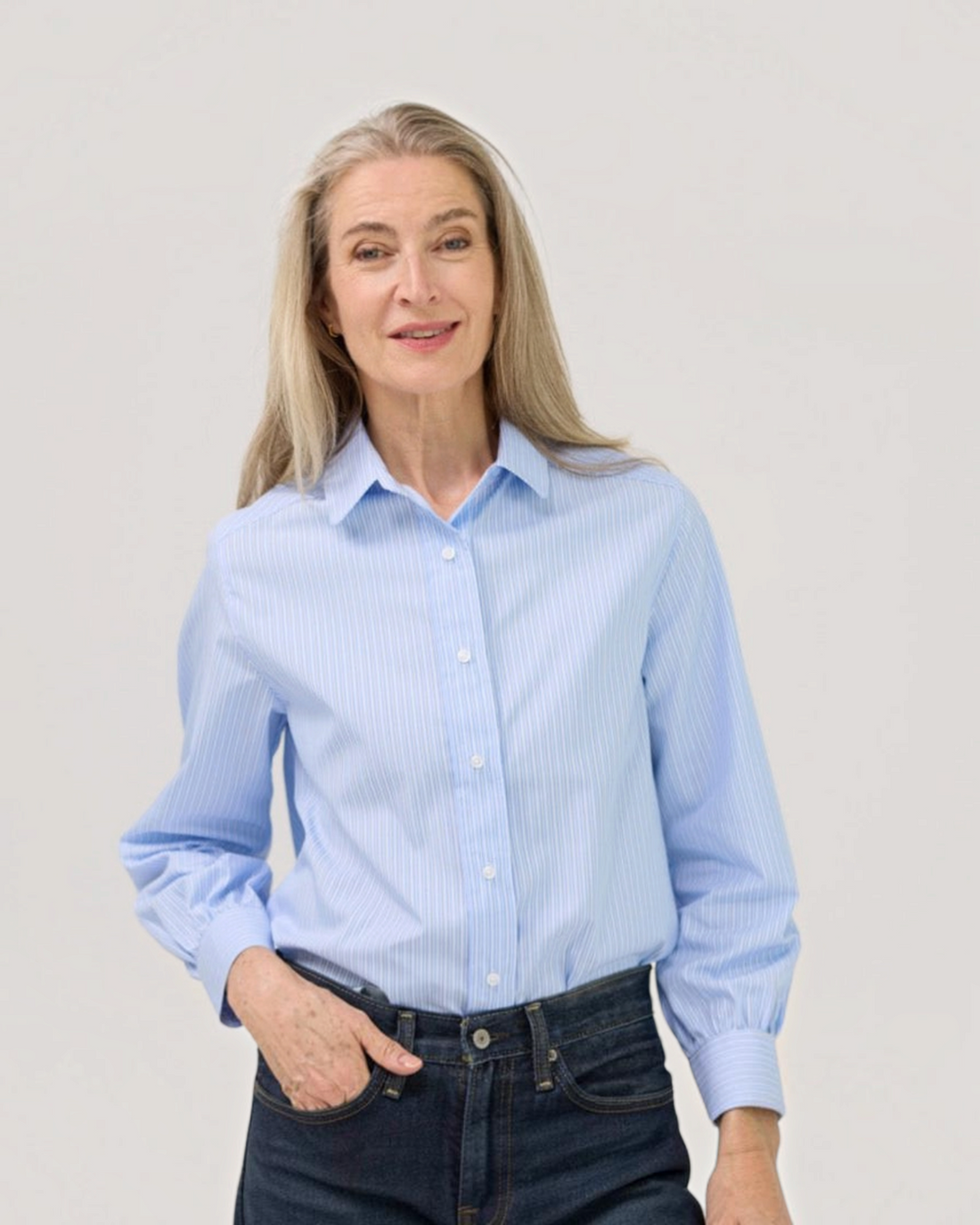 Weldun blue and white striped cotton blouse with magnetic closures and a band collar worn by a mature woman.