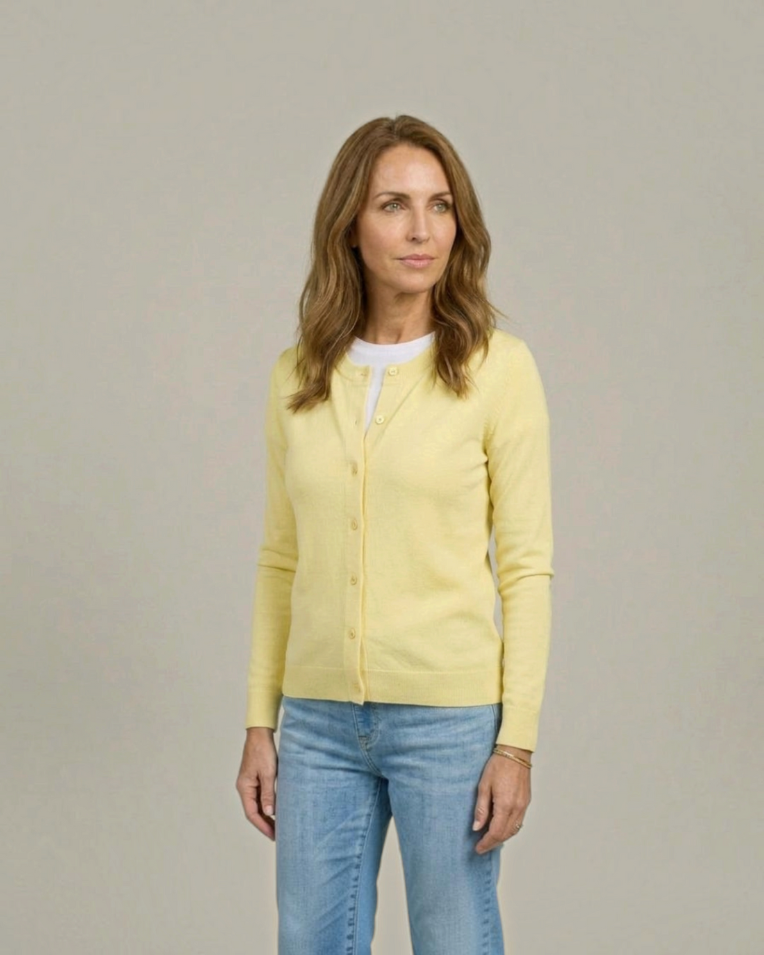 Weldun model wearing a yellow adaptive knit cardigan with magnetic front closures over a white t-shirt and blue jeans.
