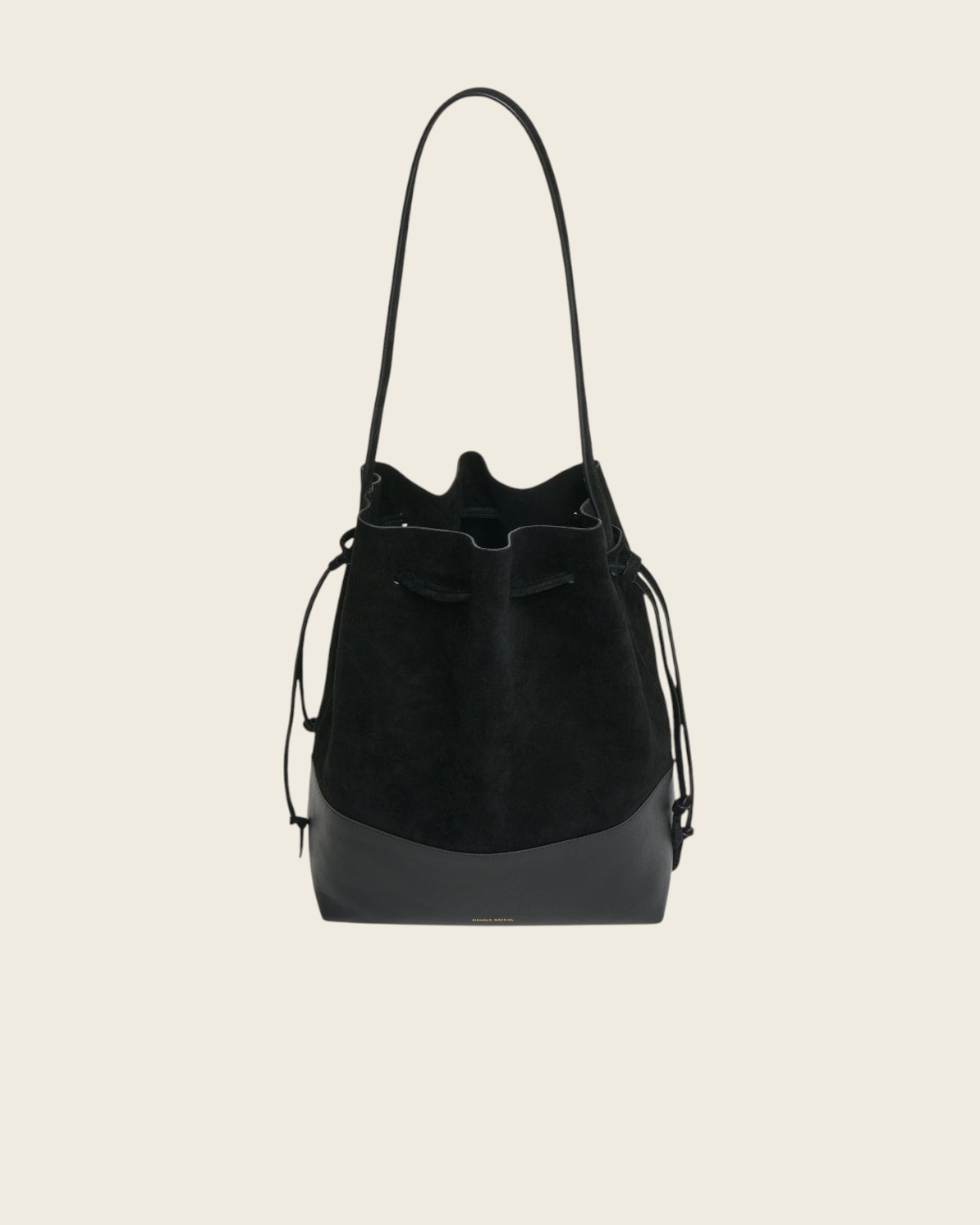 Weldun Mansur Gavriel black suede and leather drawstring bucket bag with long shoulder straps on a white background.