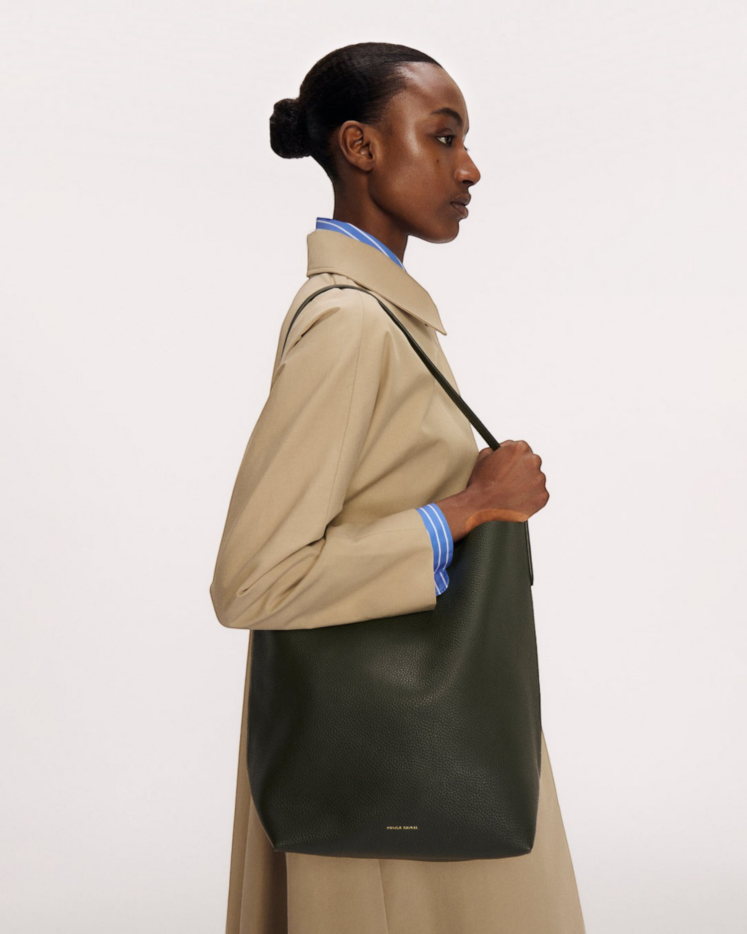 Weldun Mansur Gavriel Everyday Cabas in Anise green pebbled leather worn over the shoulder by a model in a trench coat