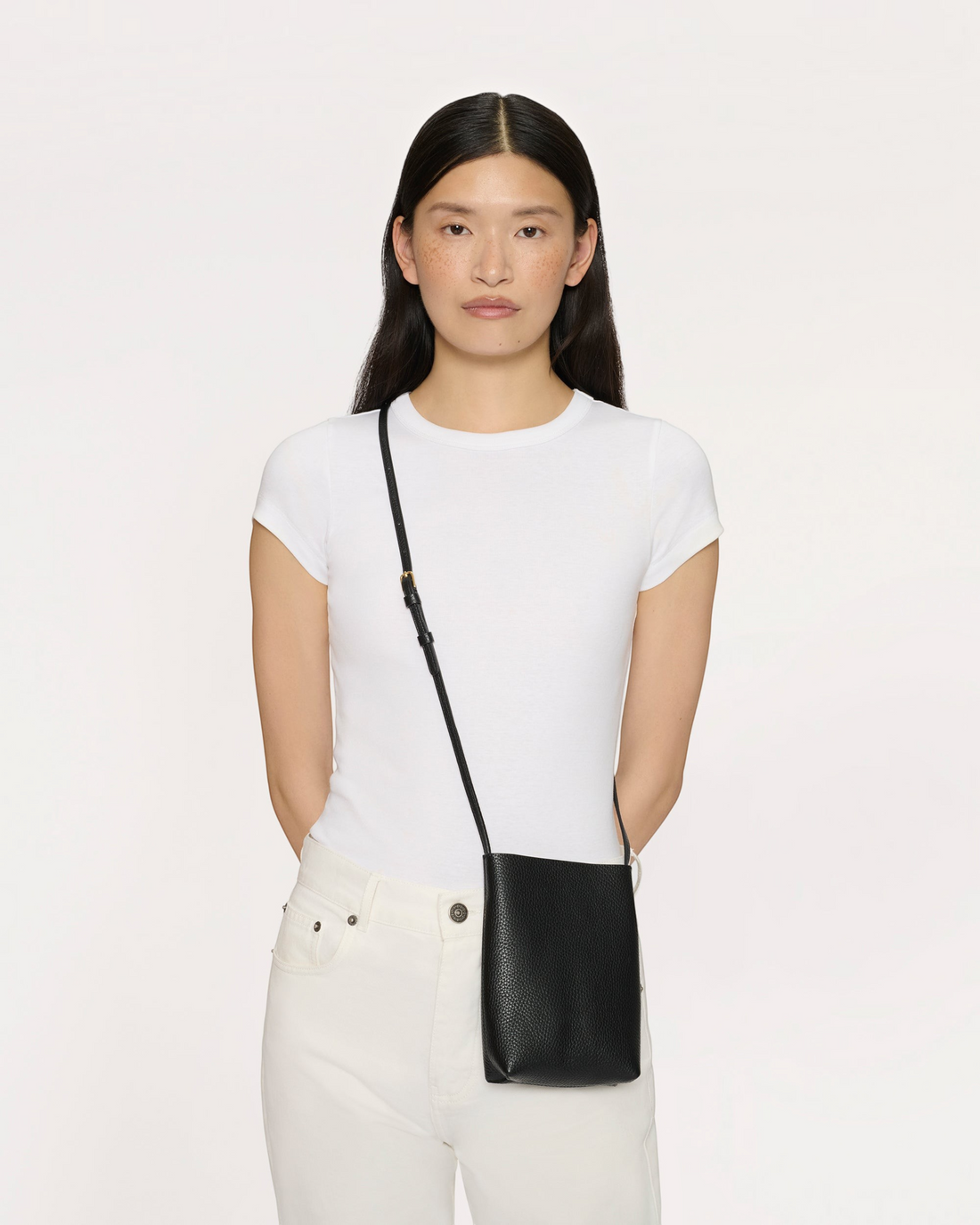 Weldun Mansur Gavriel black pebbled leather Everyday Cabas crossbody bag worn by a model in a white t-shirt