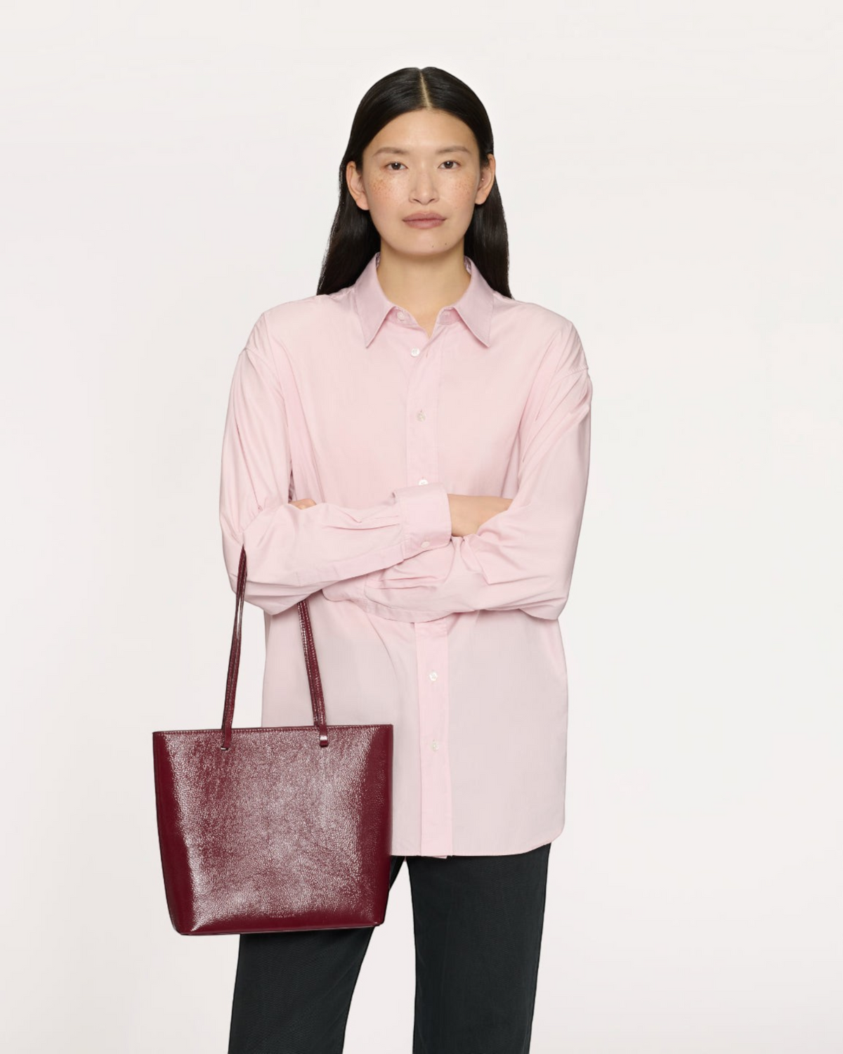 Weldun Mansur Gavriel Filo Tote in claret naplak laminated Italian leather with shoulder straps on a model