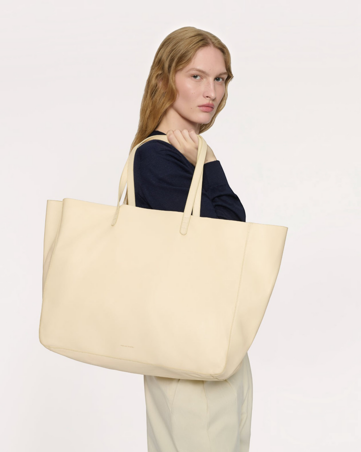 Weldun Juno oversized cream lambskin leather tote bag carried on the shoulder by a model