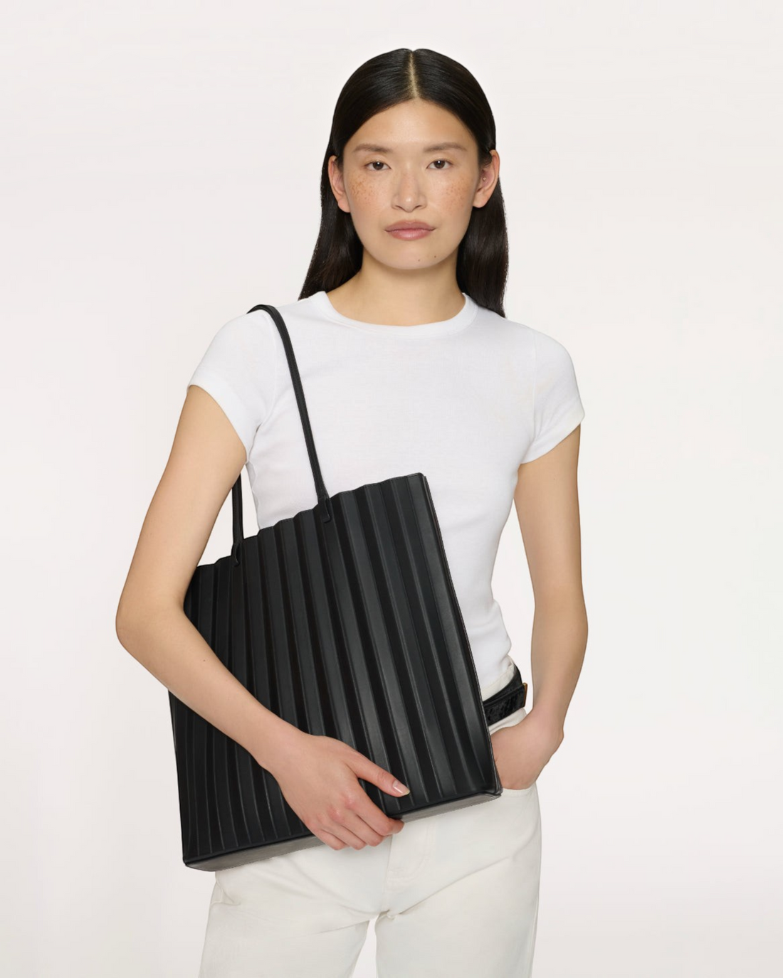 Weldun Mansur Gavriel large black pleated leather Filo tote bag with shoulder straps held by a model