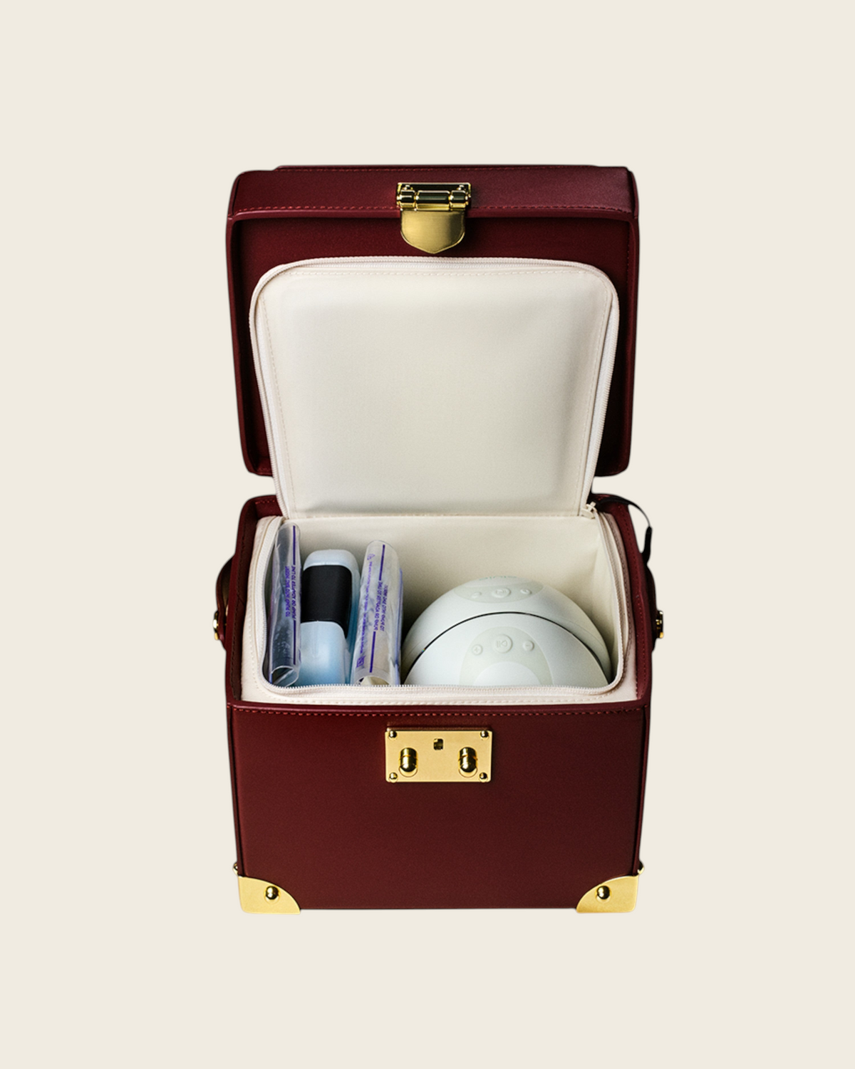 Weldun Themis breastmilk cooler in deep red nappa leather with gold hardware, showing the open insulated interior.