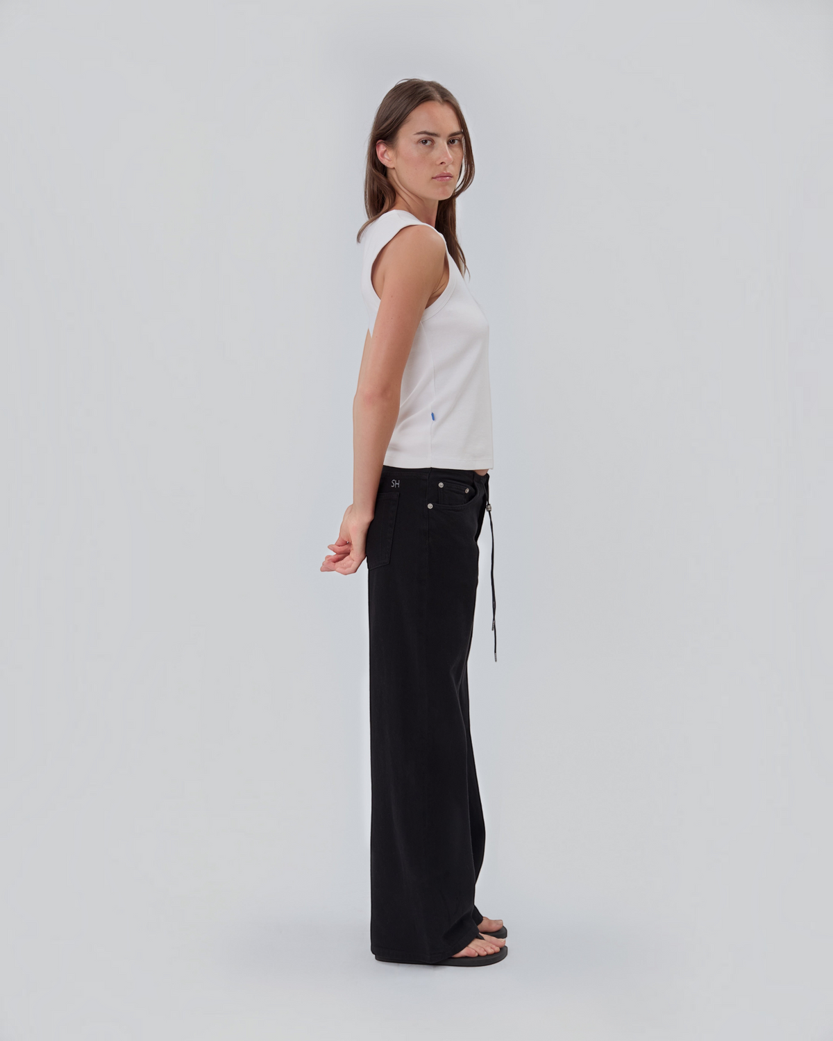 Weldun Still Here black relaxed leg jeans with elastic drawstring waist and SH embroidery, worn by a model