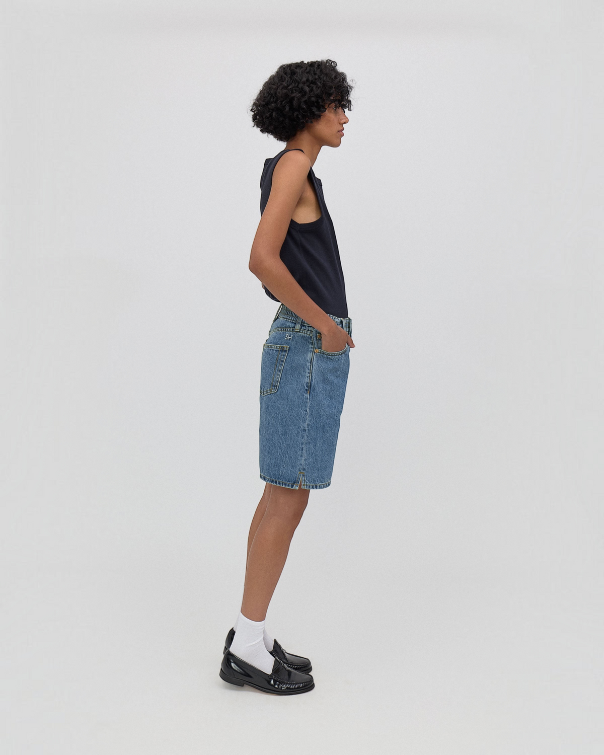 Model wearing Weldun Lola high-waisted denim shorts in classic blue with side-seam slits and elastic waistband