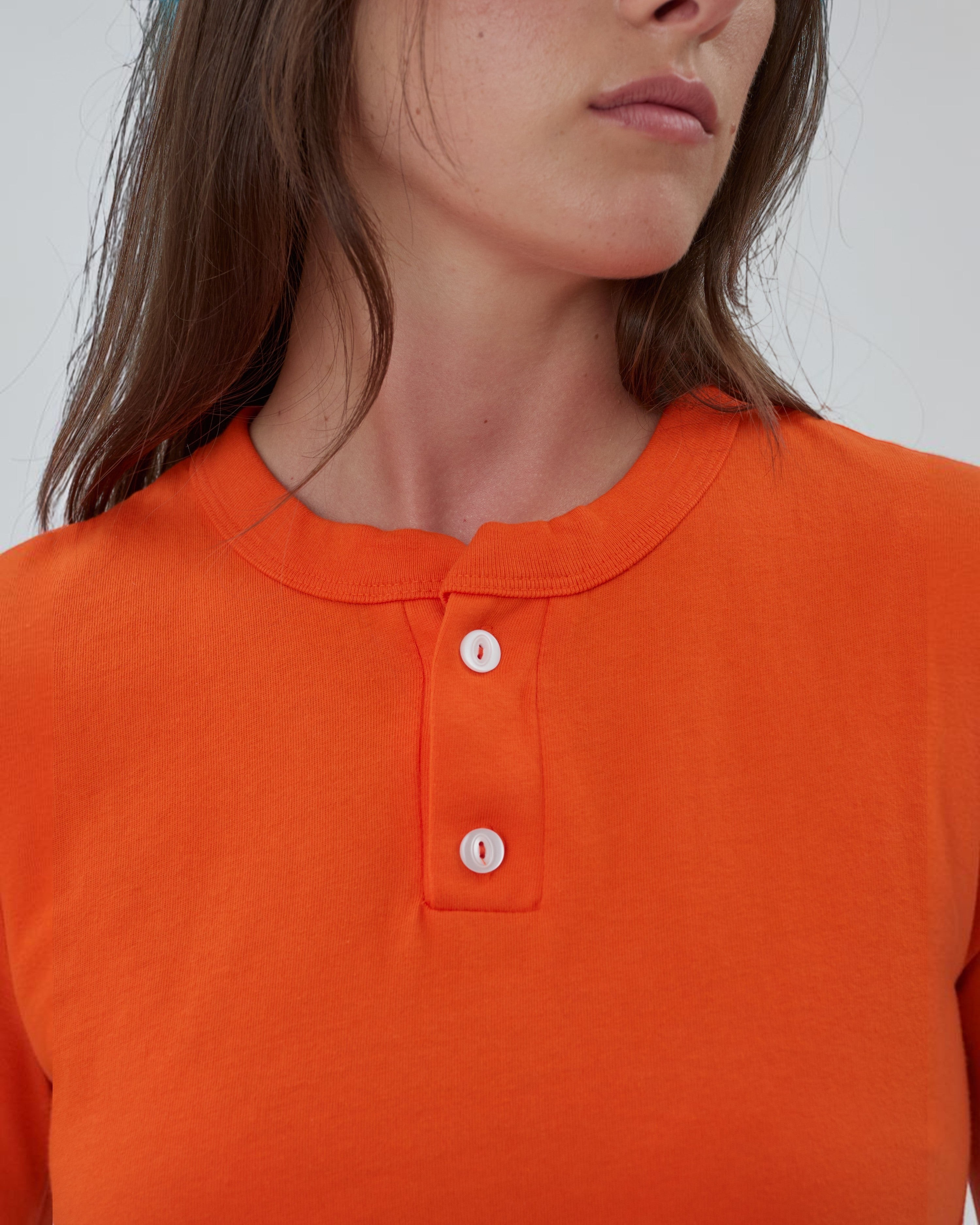 Weldun orange cotton Henley shirt with a two-button placket and crewneck, worn by a model.