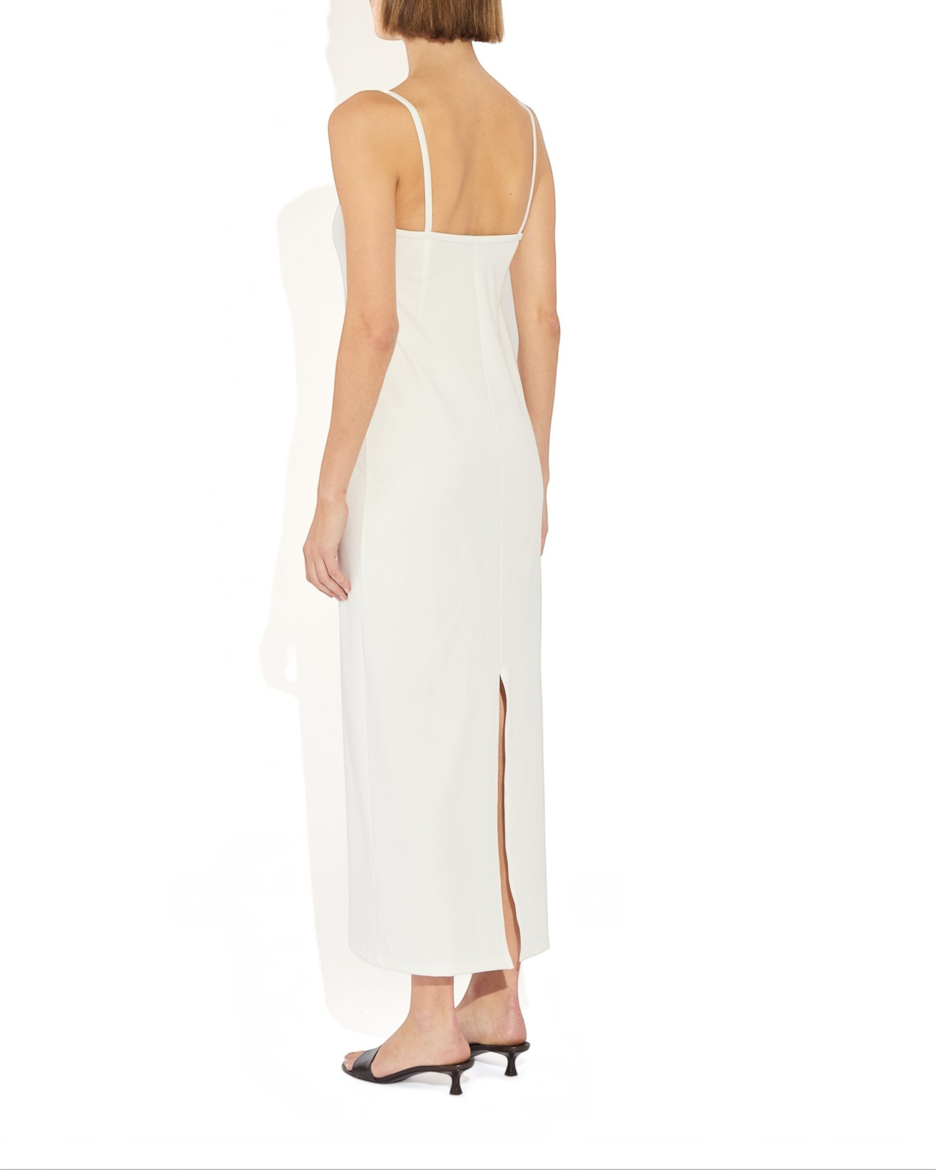 Weldun Alexandra maxi column dress in white with thin straps, square neckline, and back slit on a model