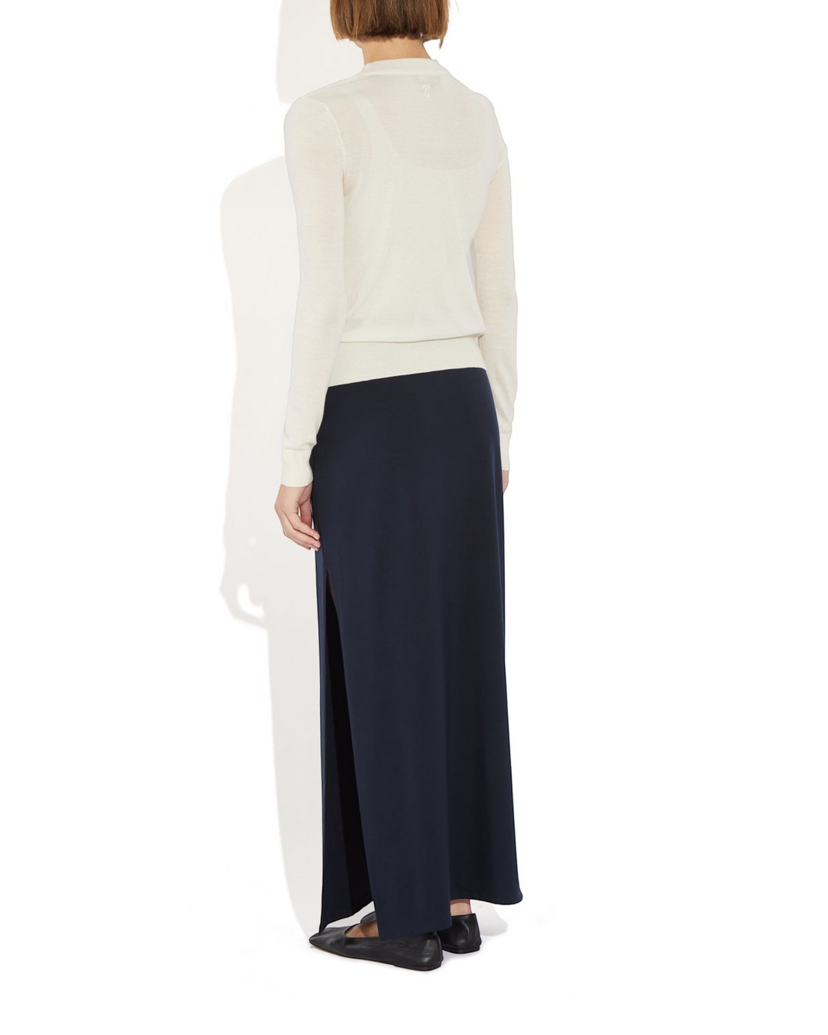 Weldun Ashley Skirt in navy blue with a side slit, worn by a model in a column silhouette with a cream top.