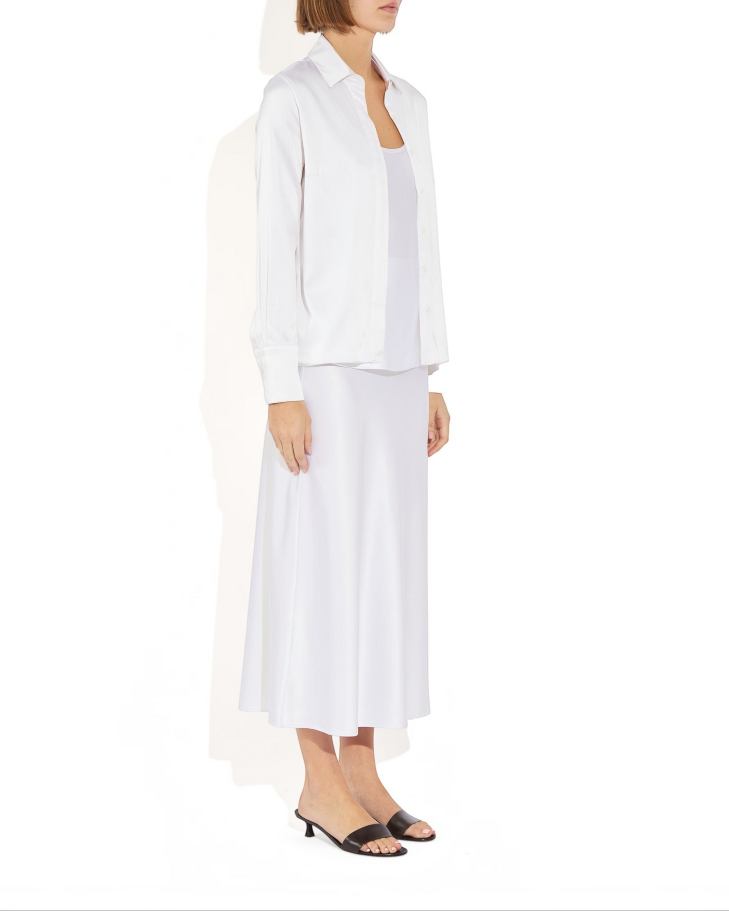 Weldun Bonnie Blouse in white stretch silk with a collared neckline and long sleeves, worn over a matching skirt.