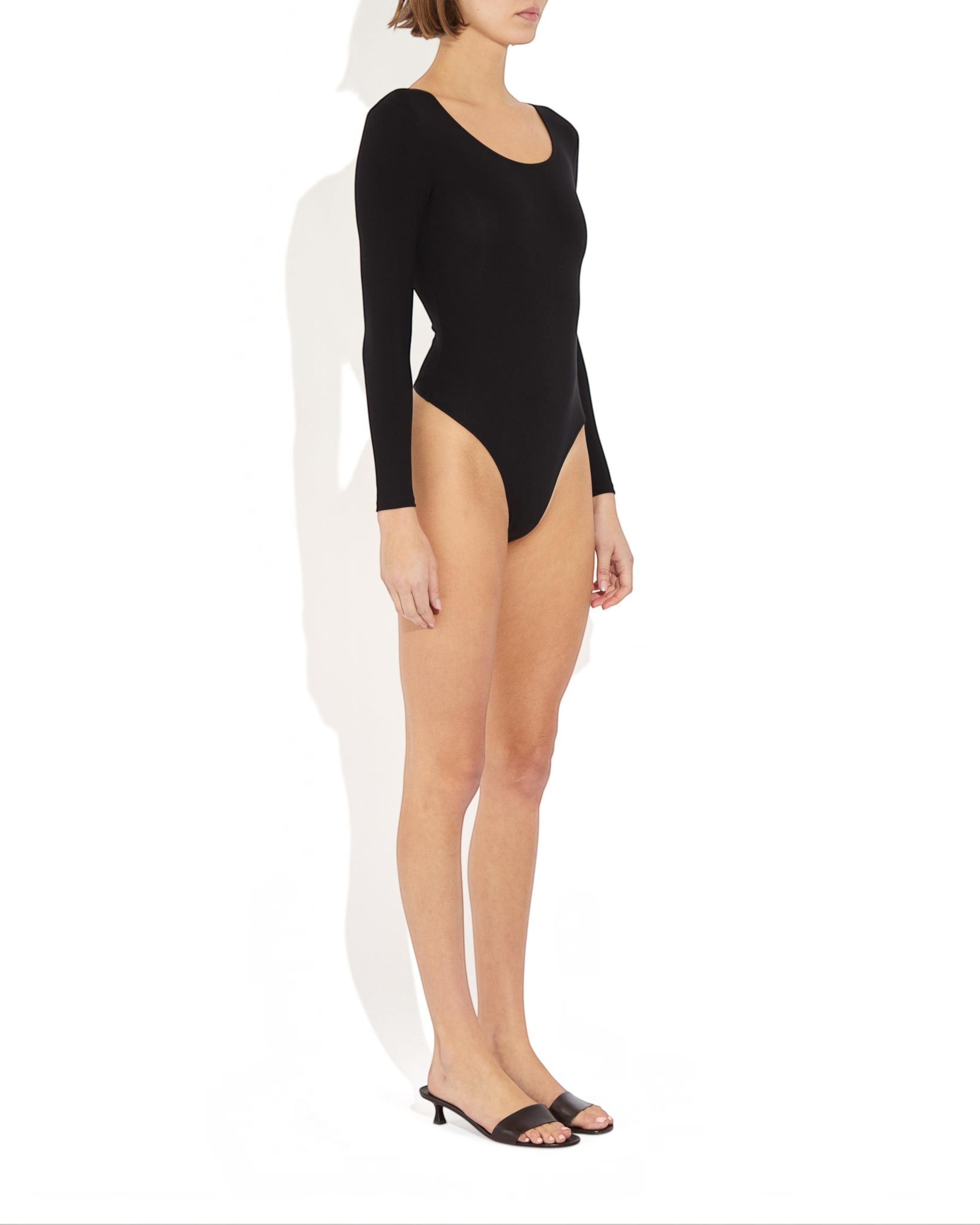 Weldun Donna long-sleeve black bodysuit with a scoop neckline and cheeky cut, worn by a model on a white background.