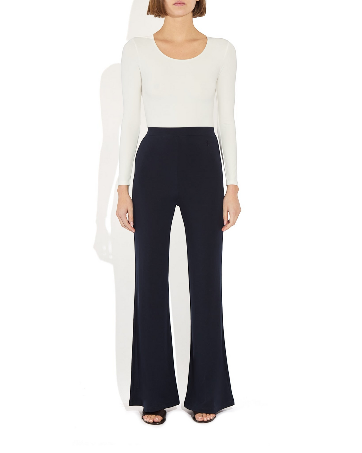 Weldun Donna long-sleeve scoop neck bodysuit in white paired with navy blue wide-leg trousers on a model