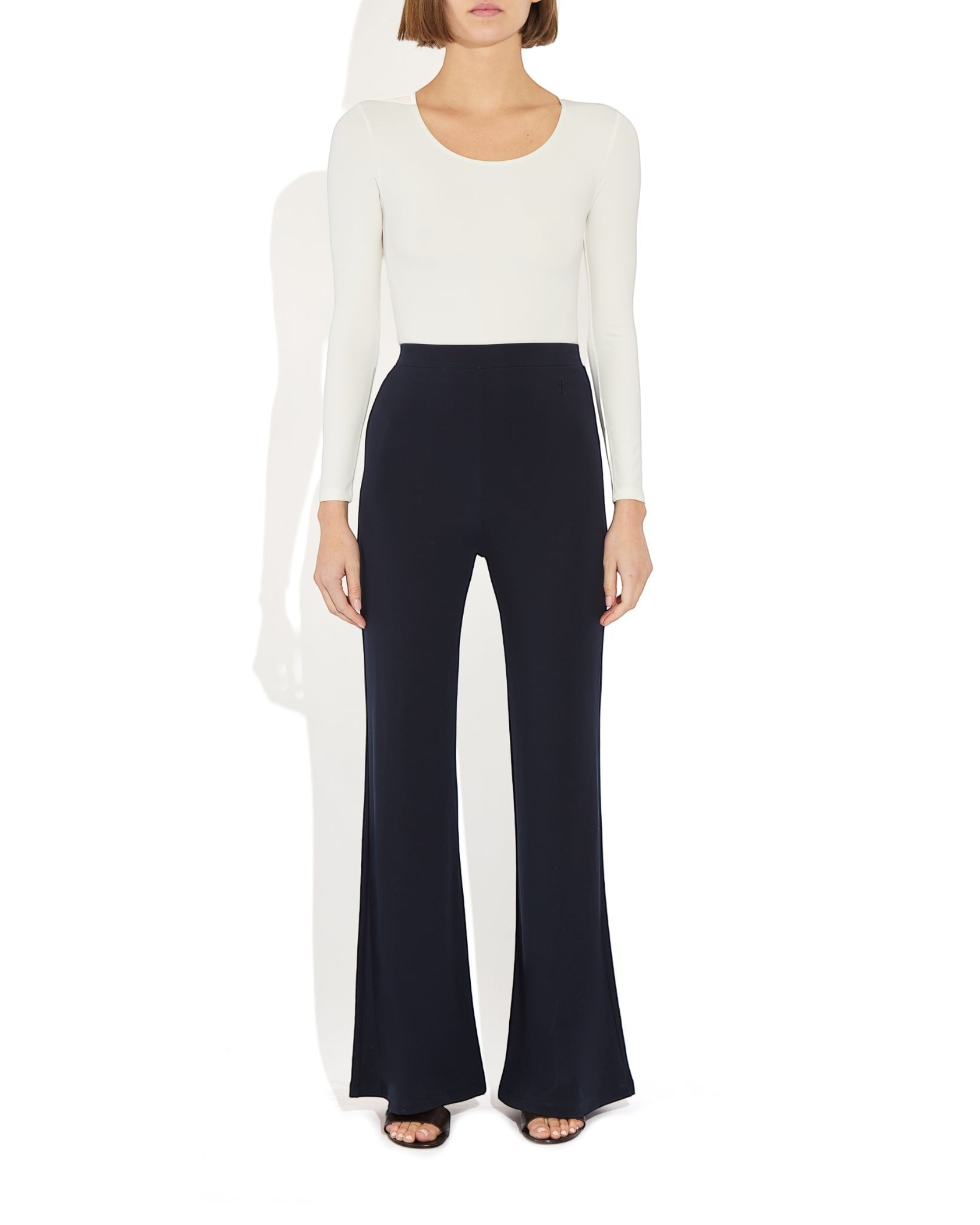 Weldun Donna long-sleeve scoop neck bodysuit in white paired with navy blue wide-leg trousers on a model