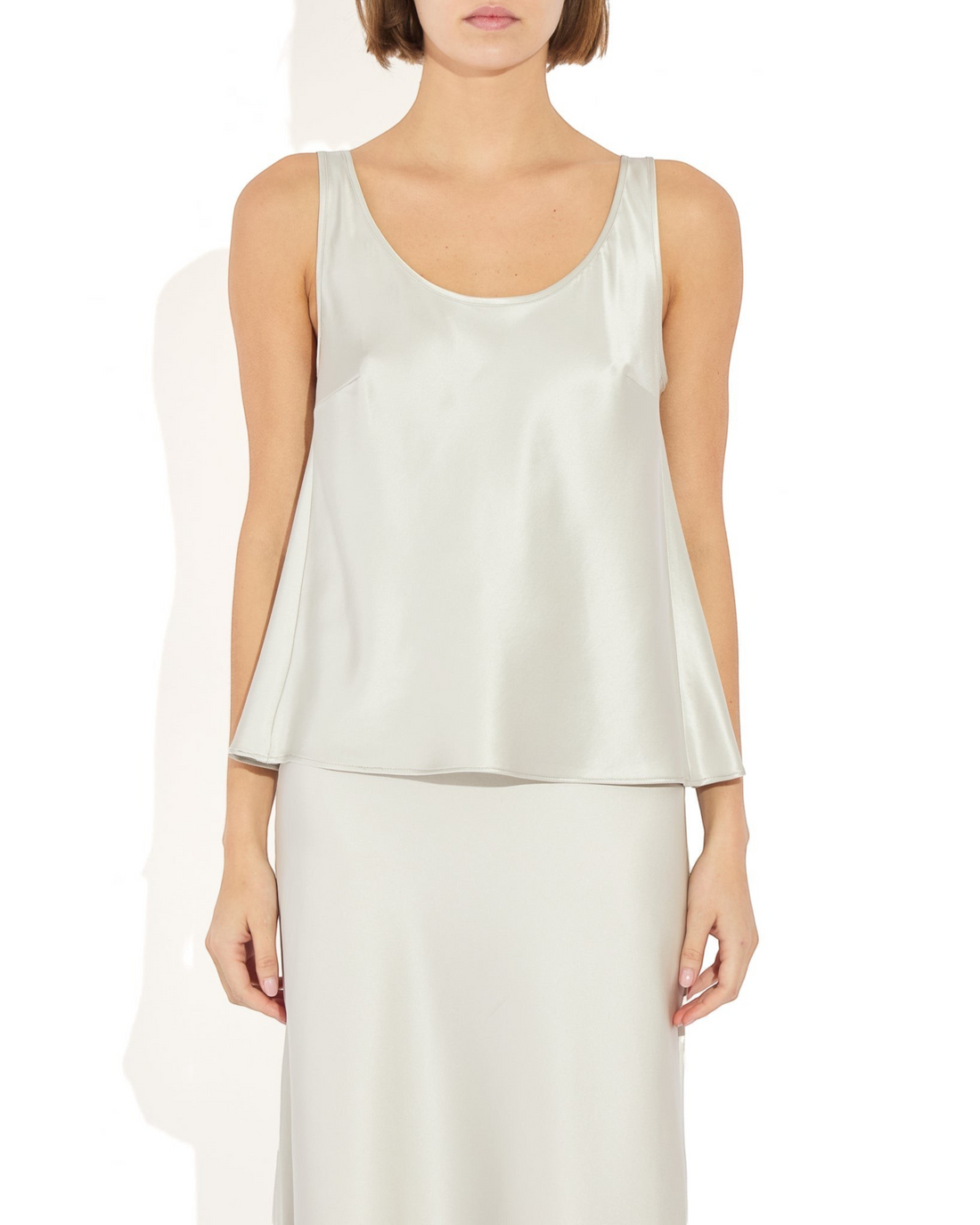 Weldun Karen Tank in silver stretch silk with a scooped neckline and fluid bias-cut drape on a model
