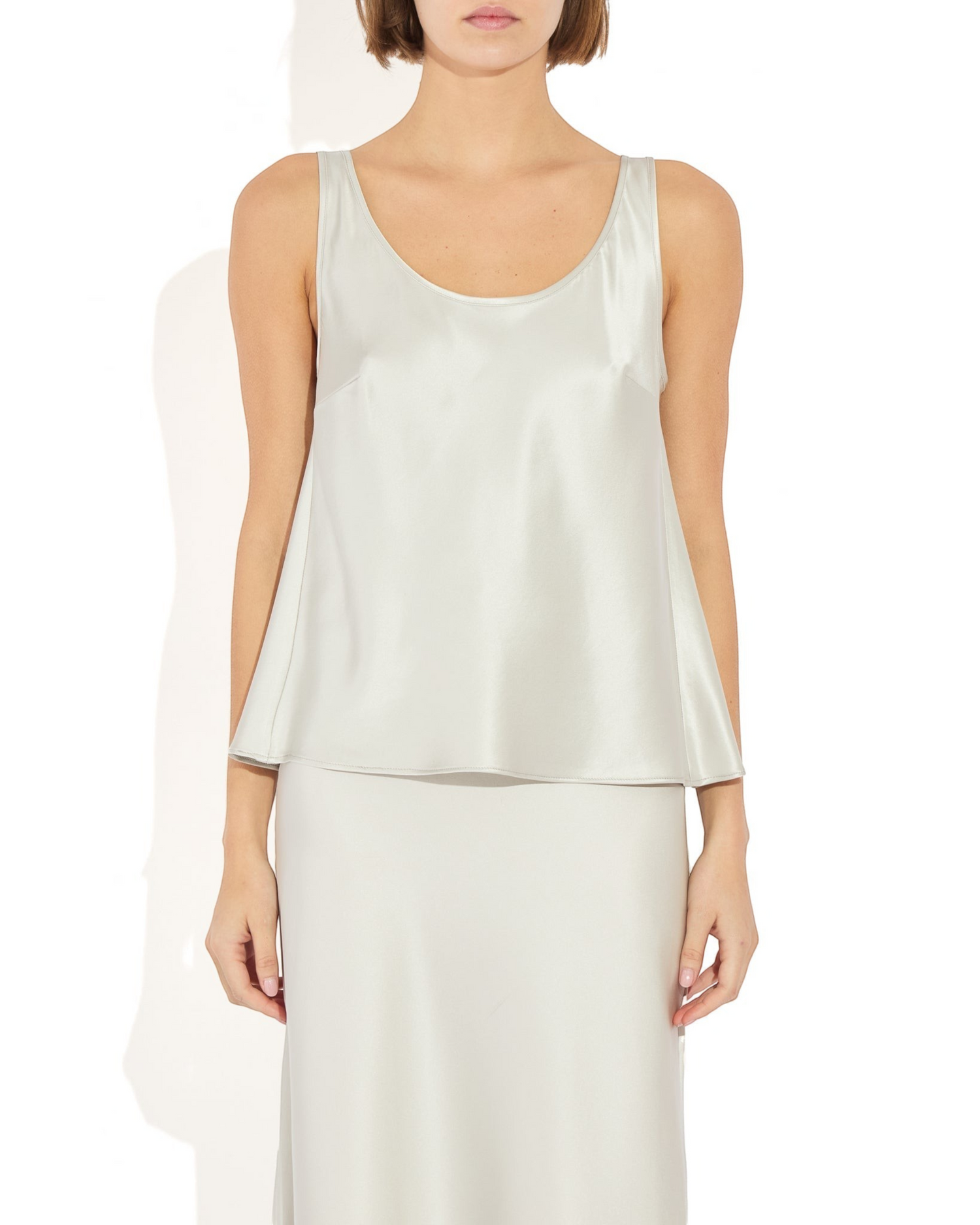 Weldun Karen Tank in silver stretch silk with a scooped neckline and fluid bias-cut drape on a model