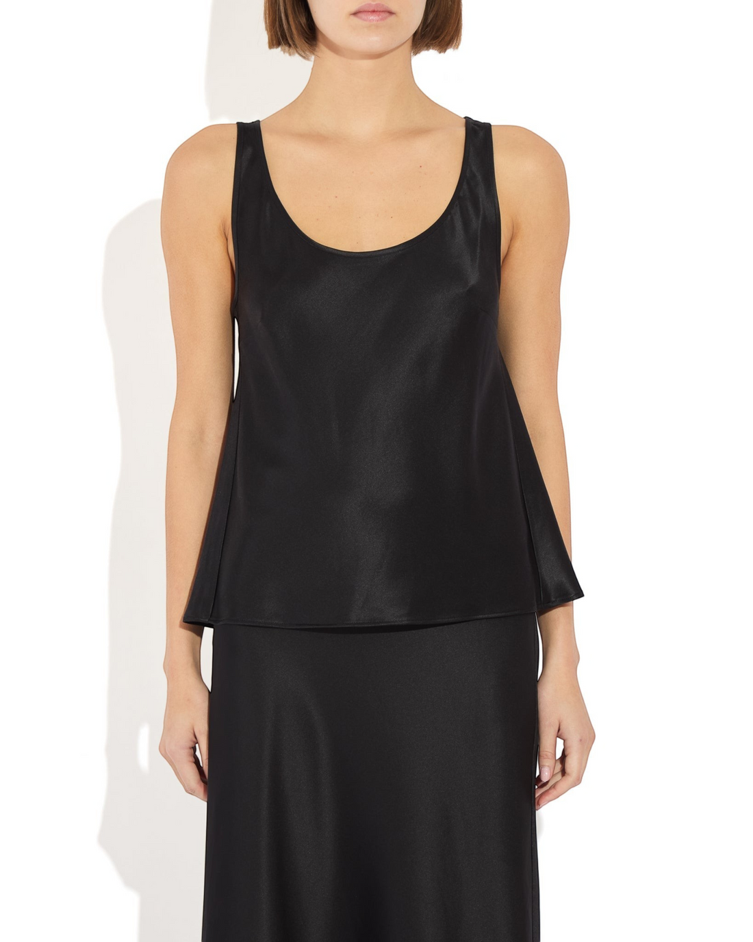 Weldun Karen Tank in black stretch silk with a scoop neckline and fluid bias-cut drape on a model