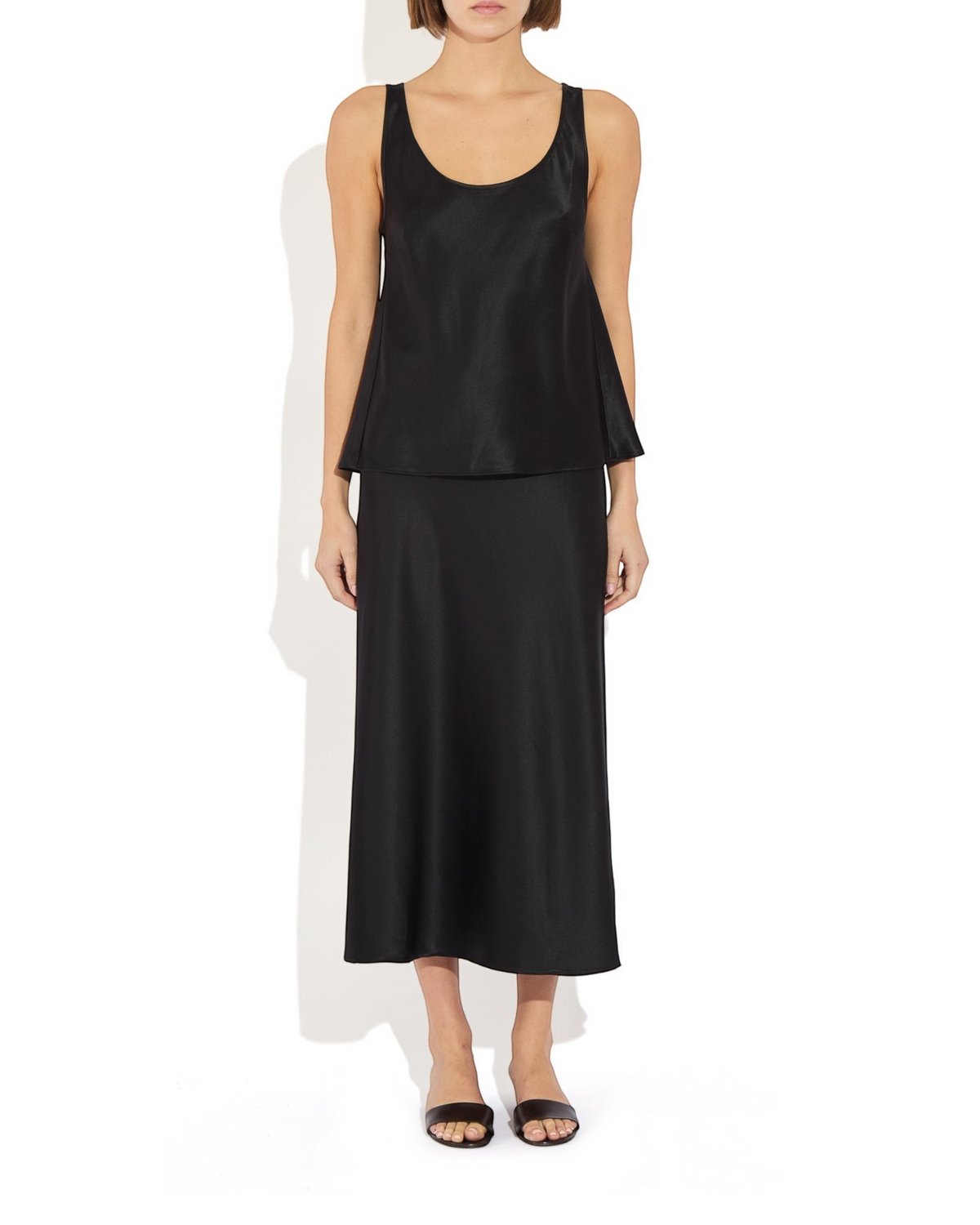 Weldun Karen Tank in black stretch silk with a scooped neckline, worn with a matching skirt on a model.