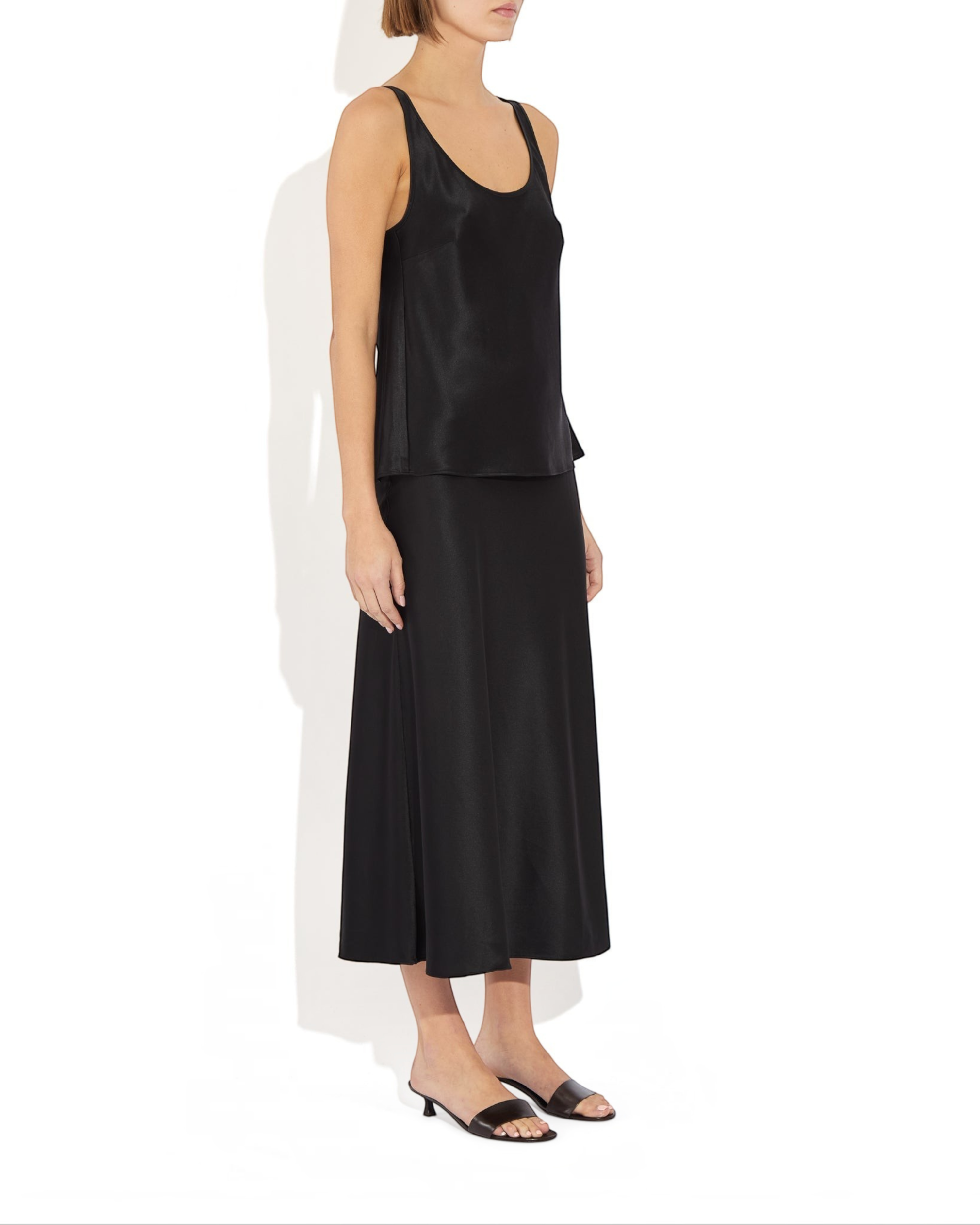 Weldun Karen Tank in black stretch silk with a scooped neckline and fluid bias-cut drape worn with a matching skirt.