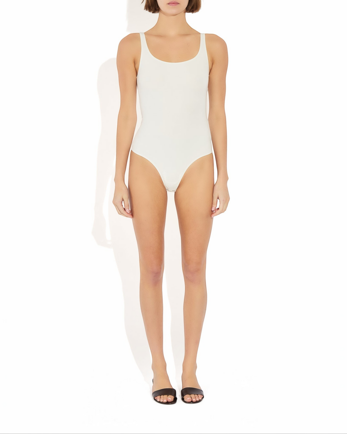 Model wearing a Weldun white Lisa tank bodysuit with a scoop neckline and cheeky cut in breathable stretch fabric