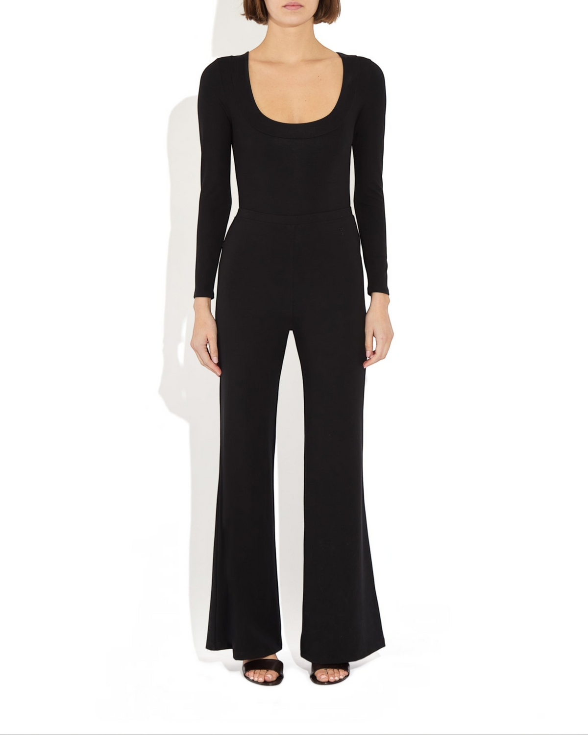 Weldun Maranda black long-sleeve bodysuit with a low scoop neckline and structured banded finish on a model.