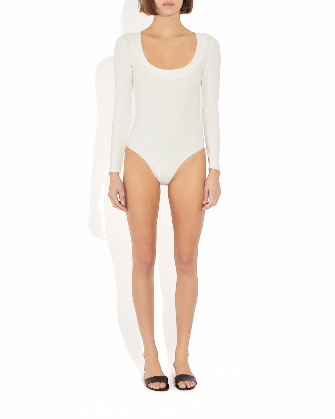 Weldun Maranda long-sleeve bodysuit in white with a low scoop neckline and structured banded trim on a model