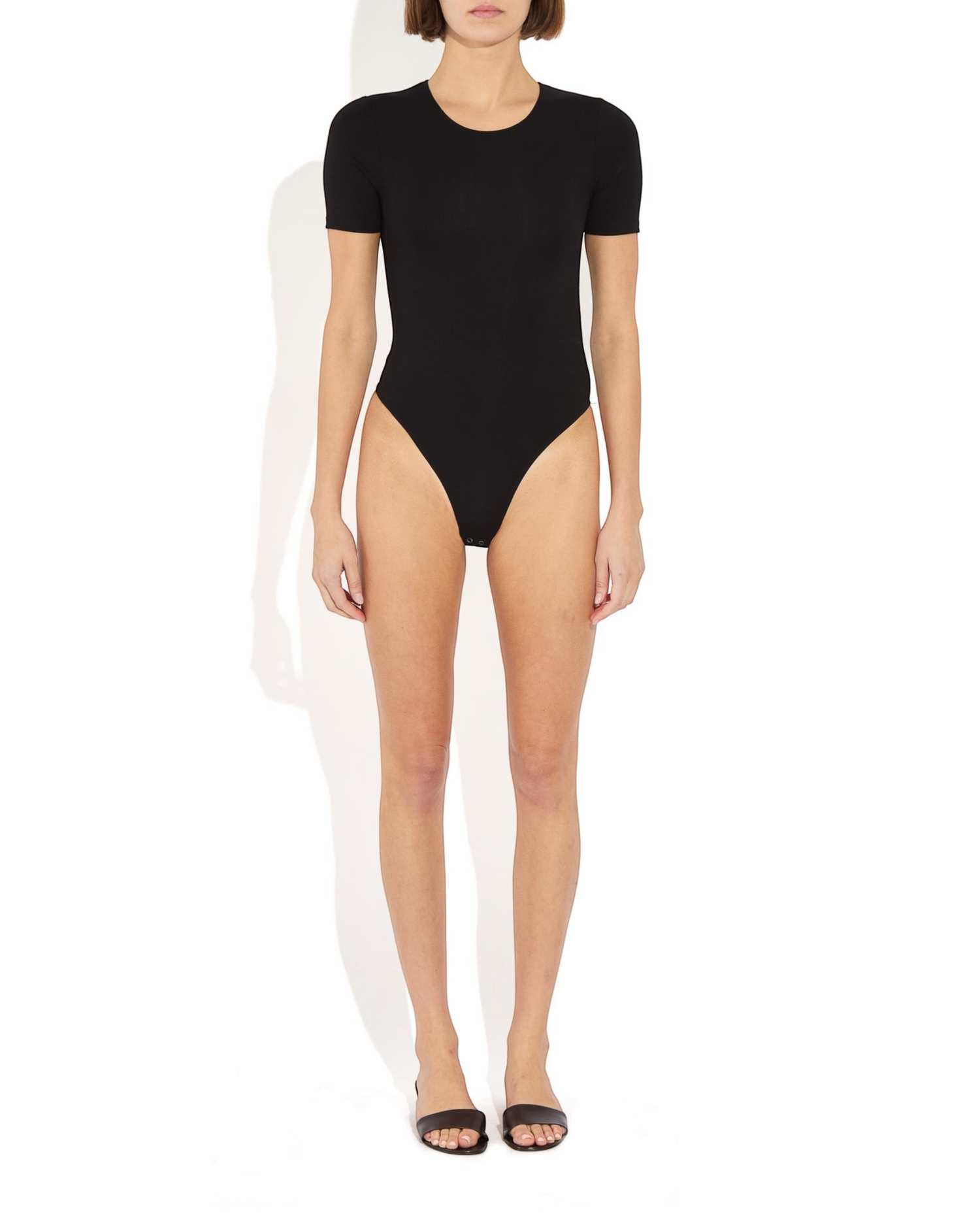Weldun Penny short-sleeve black bodysuit with a ballerina neckline and cheeky fit on a model against a white background