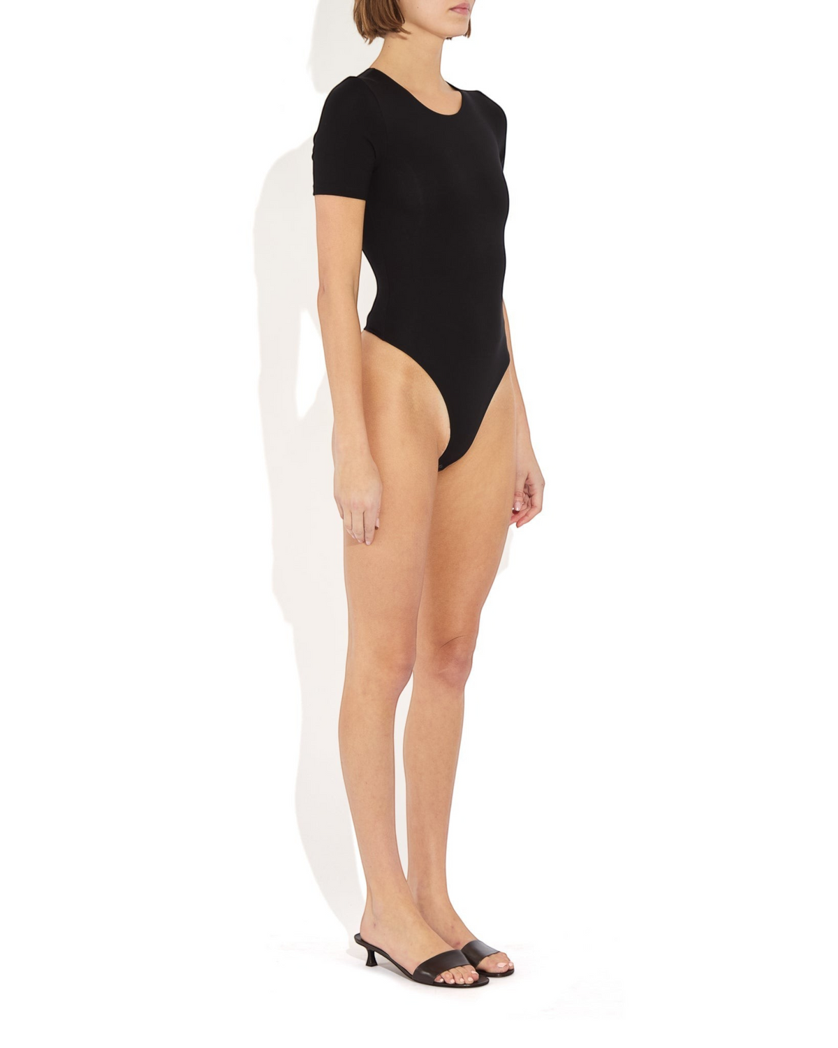 Weldun Penny short-sleeve black bodysuit with a ballerina neckline and cheeky bottom coverage on a model
