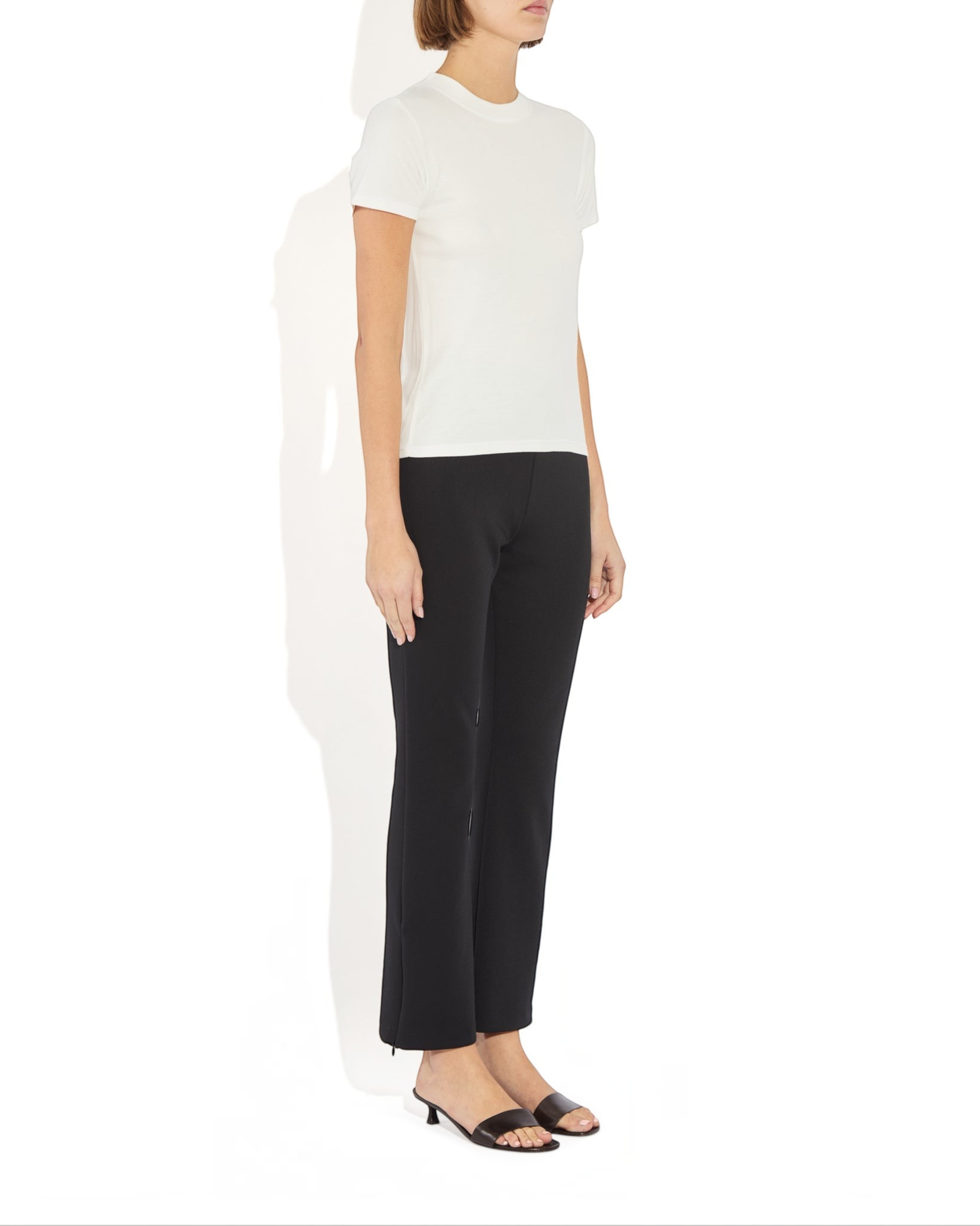 Weldun Sarah Pant in black recycled polyester with side hem zippers, worn by a model in a studio setting.