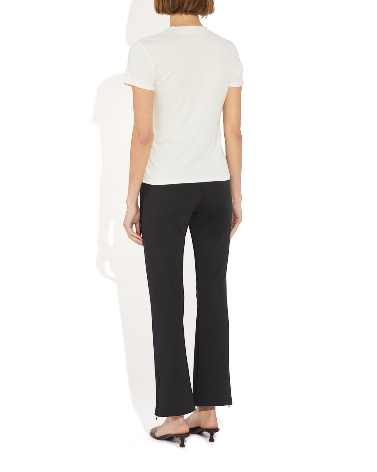 Weldun Sarah Pant in black recycled stretch fabric with side hem zippers worn by a model from the back view