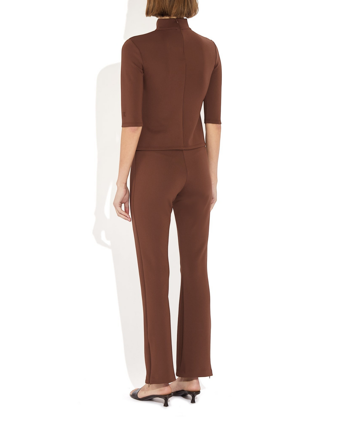 Weldun Sarah Pant in brown recycled polyester with side hem zippers, worn by a model in a back view.