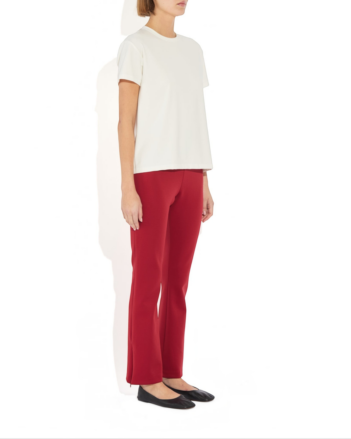 Model wearing Weldun Sarah Pant in red with side hem zippers and elastic waistband, paired with a white t-shirt.