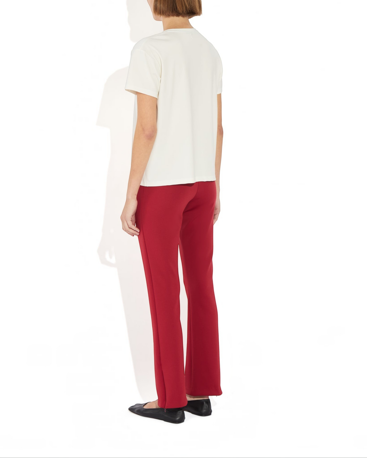 Weldun Sarah Pant in red recycled stretch fabric with side hem zippers worn by a model from the back view