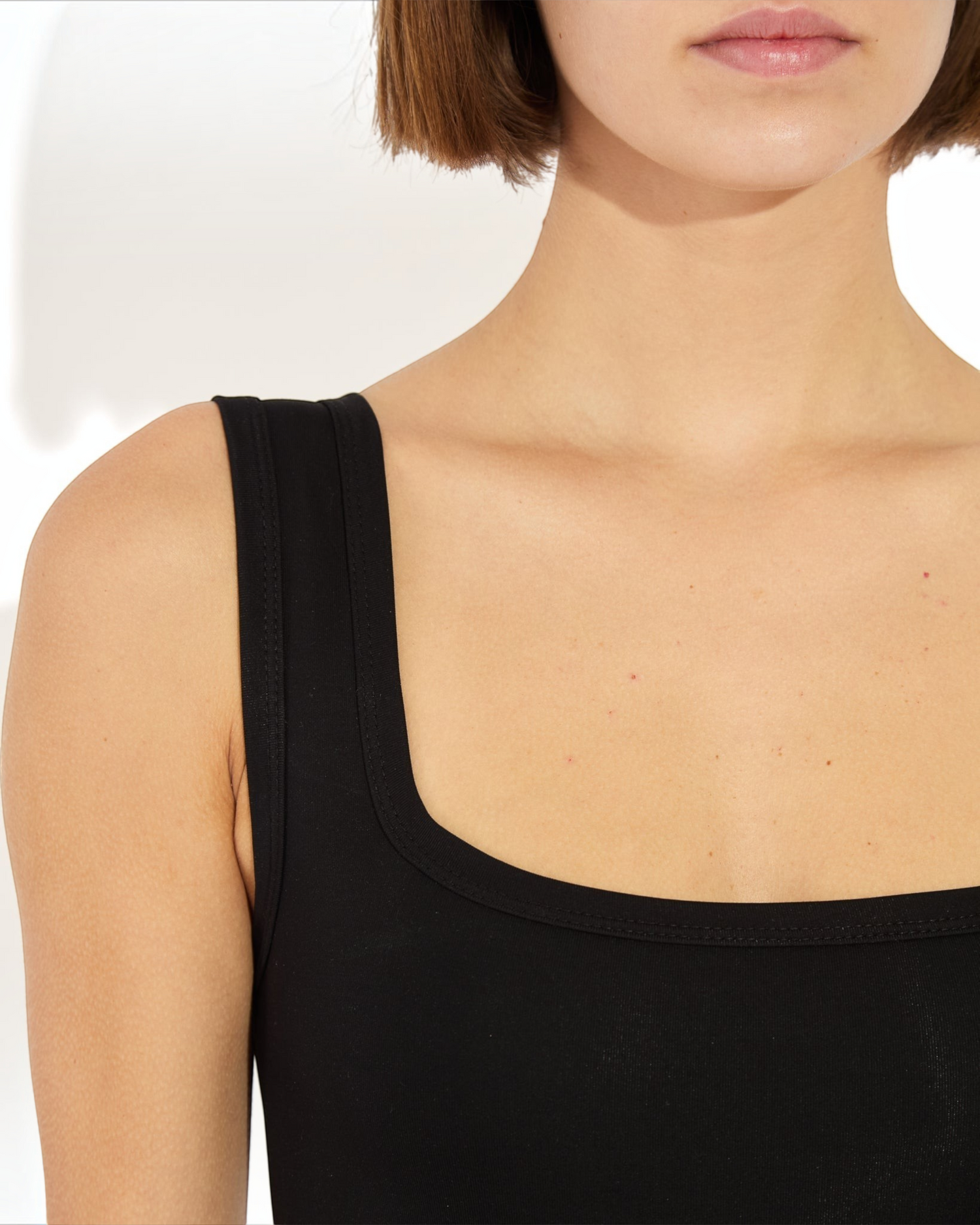 Weldun Shan black tank bodysuit with a scoop neckline and medium-thick straps in soft stretch fabric