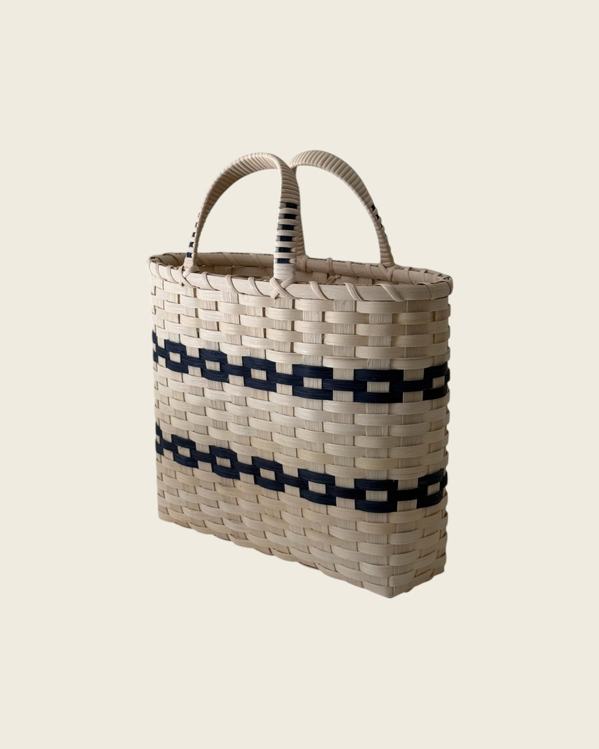 Weldun New England woven rattan shopping basket with natural and black geometric patterns and wrapped side handles.