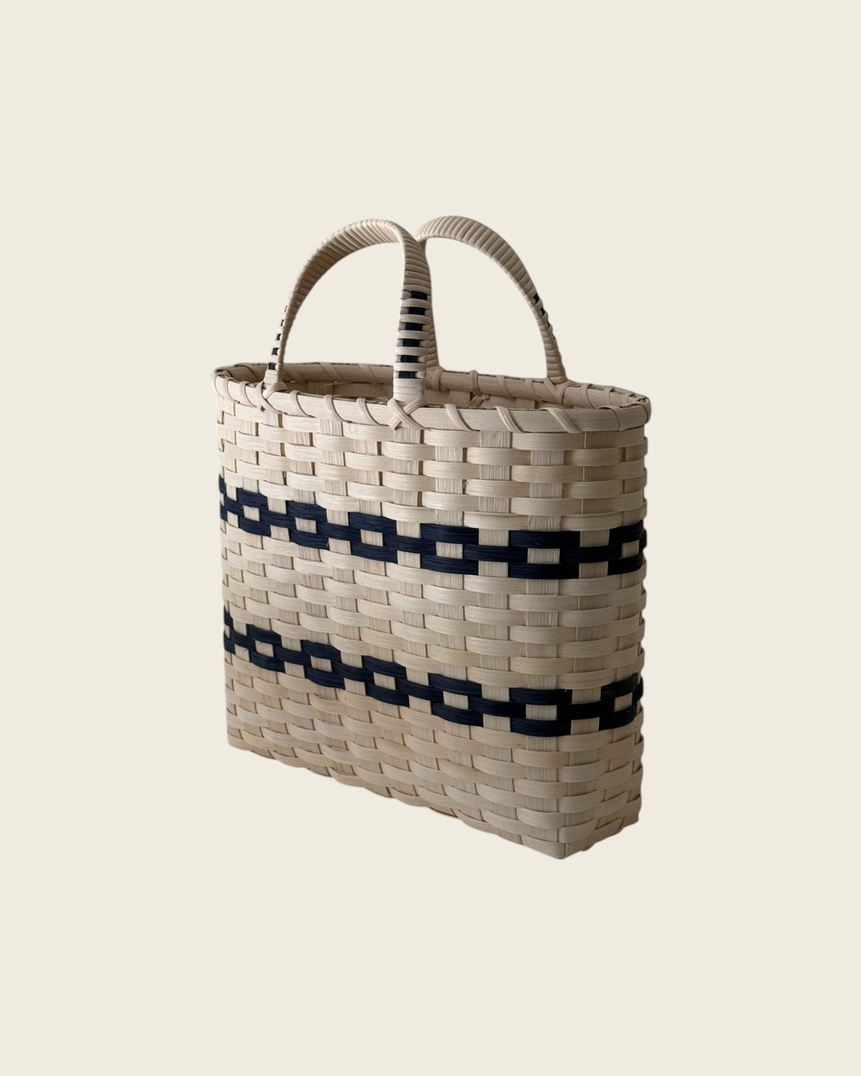 Weldun New England woven rattan shopping basket with natural and black geometric patterns and wrapped side handles.