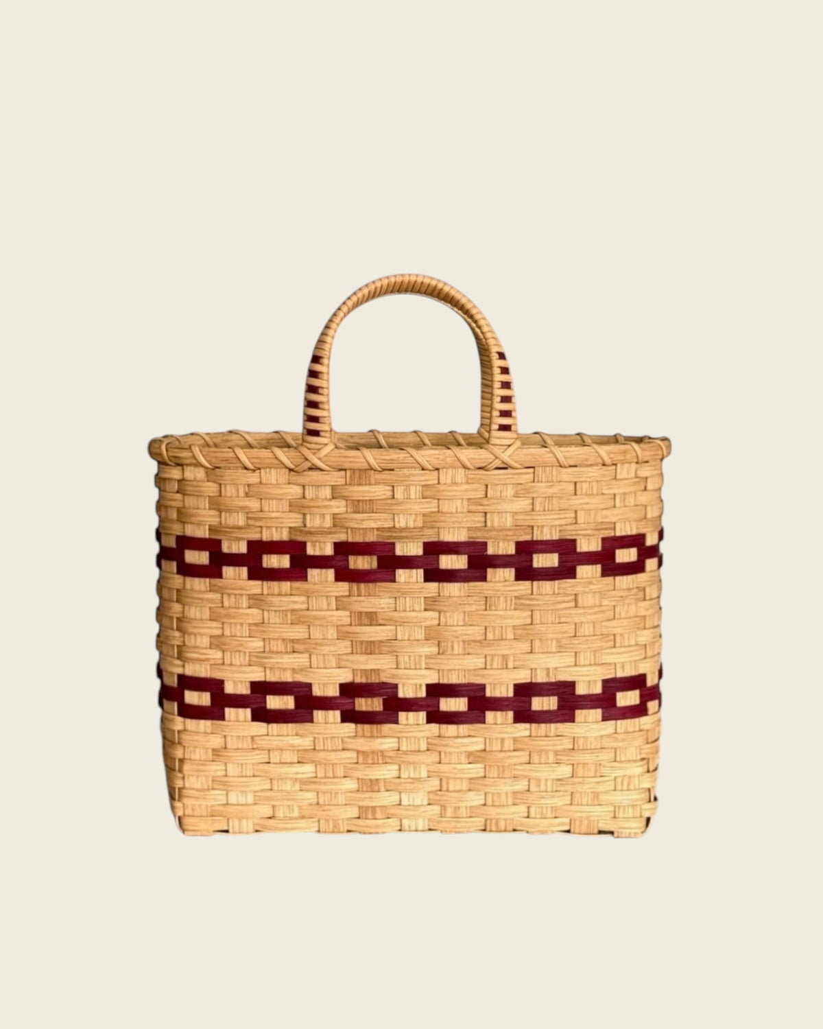 Weldun New England woven rattan shopping basket with natural beige and dark red geometric pattern and side handles.